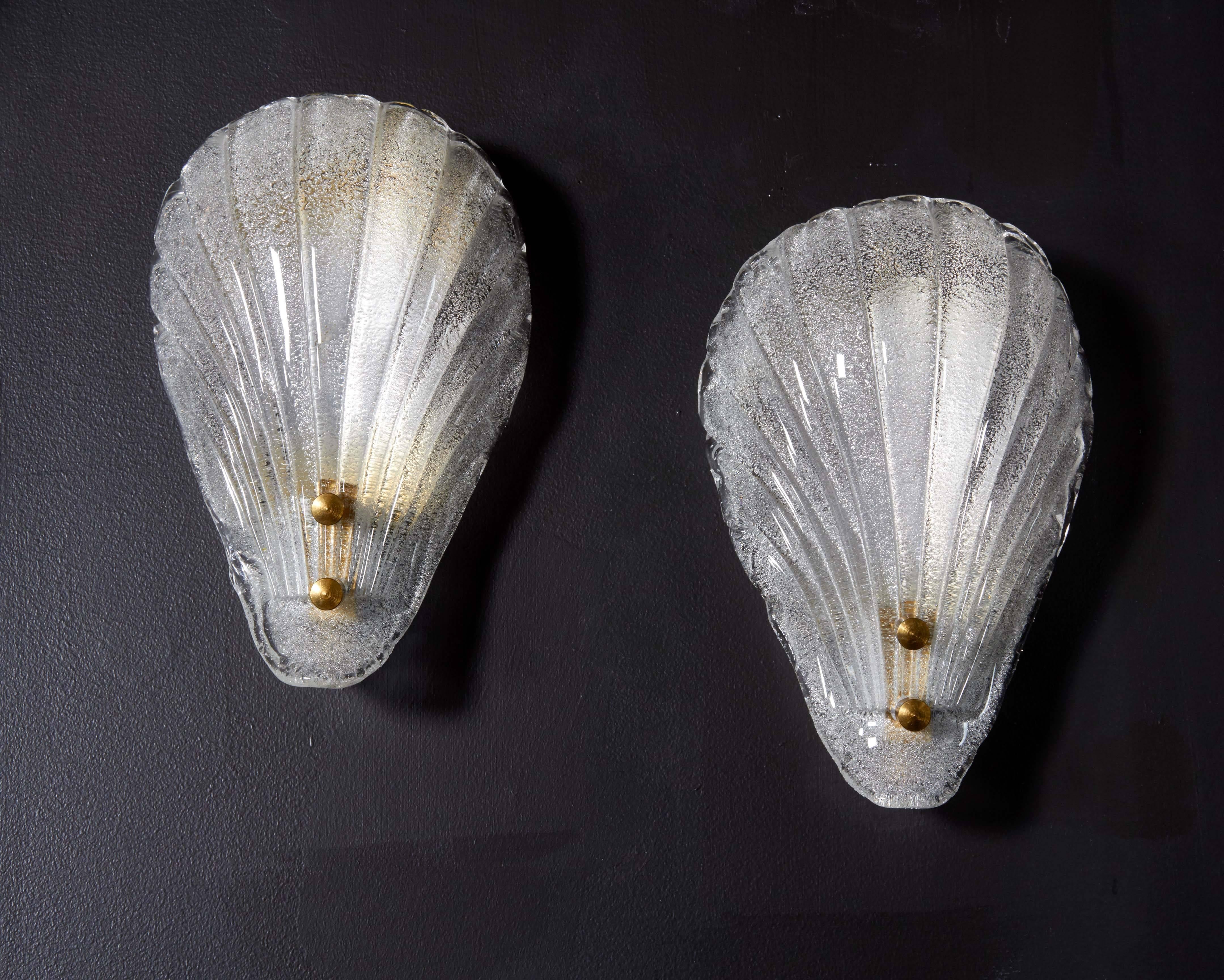 Elegant wall lights featuring stylized sea shell design in handblown Murano glass. Shades have fluted details and textural bubble technique. The hidden frame is finished in a polished brass with matching stud fittings, and has been newly rewired to