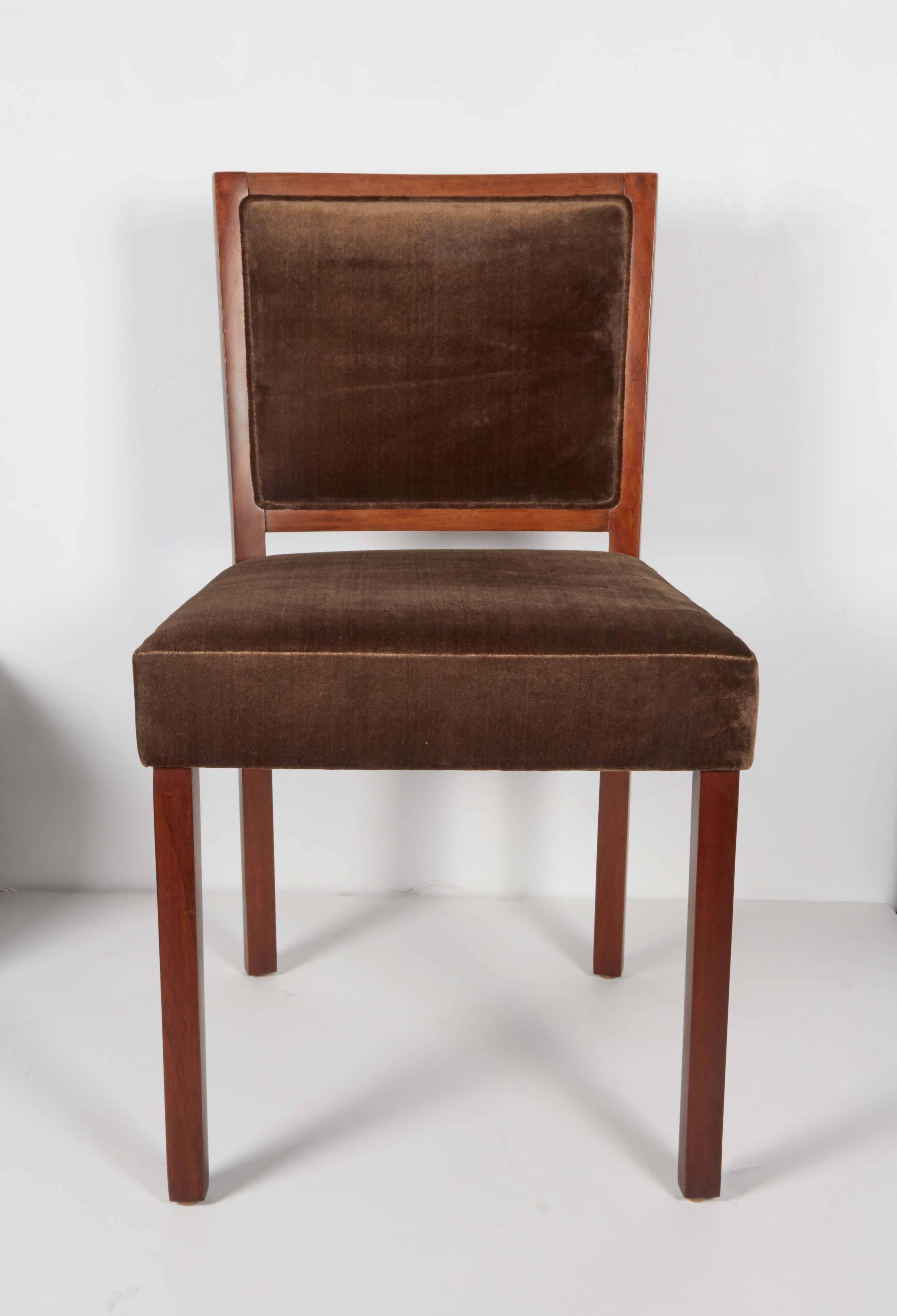 Elegant Mid-Century Modern chair with low square back design. The chair has a beautiful streamline design with clean lines and comfortable seating and back. They feature walnut wood frames in a medium brown finish and have been newly upholstered in