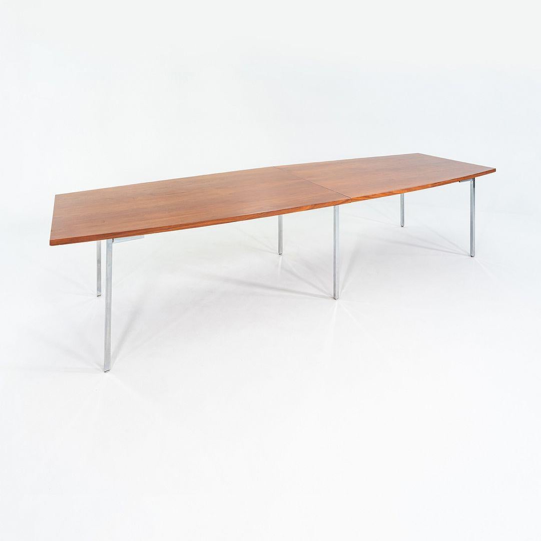 Il s'agit d'une table de conférence longue, conçue par John Widdicomb et produite et distribuée par Steelcase. Le plateau est en noyer et les pieds sont en acier chromé. Certains qualifient la forme du sommet de cette pièce de 