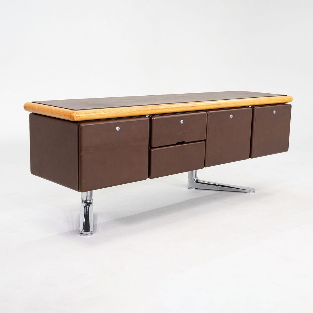 Il s'agit d'une grande crédence de direction en chêne, cuir et acier chromé, initialement conçue par Warren Platner pour Knoll International en 1973. Cette unité particulière a été produite en 1979. La crédence présente un design minimaliste, avec
