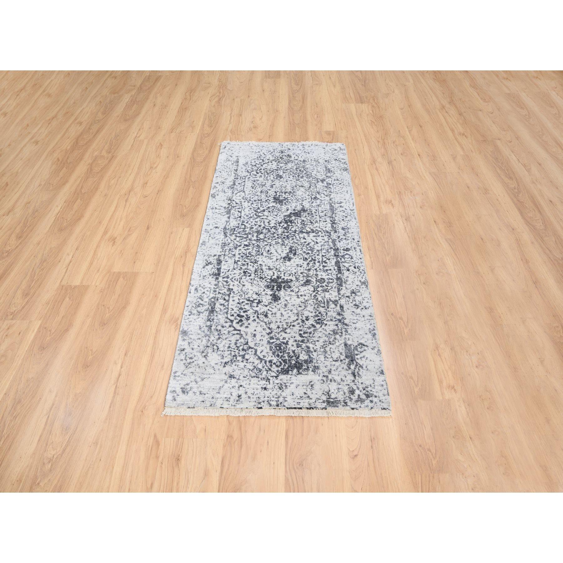 Il s'agit d'un véritable tapis de course oriental en laine et soie pure, noué à la main et unique en son genre, de couleur gris argenté et au design persan effacé. Il a été noué pendant des mois et des mois selon des techniques de tissage séculaires