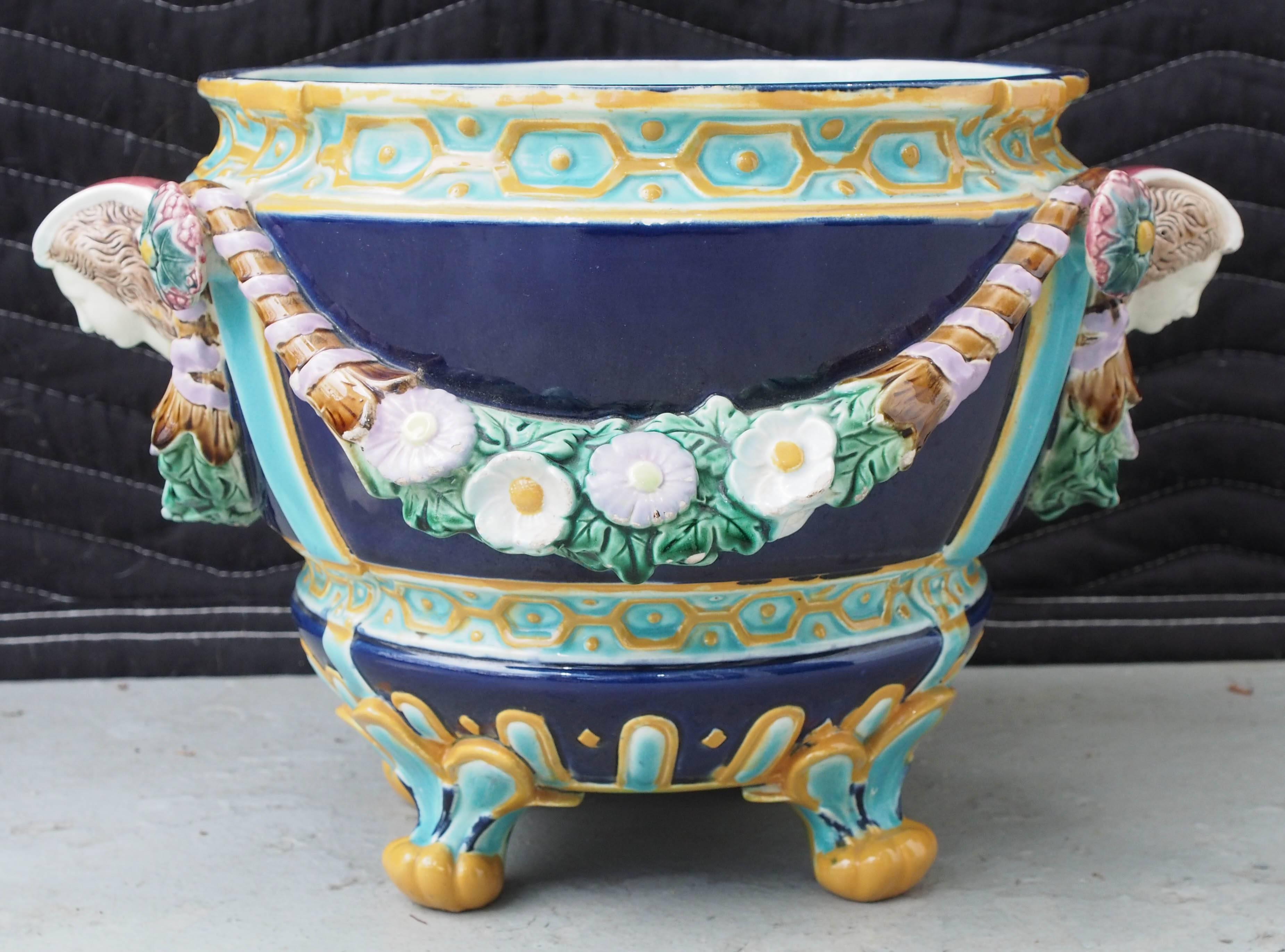 Pair of French Majolica jardiniere with floral swag and handles of female heads.