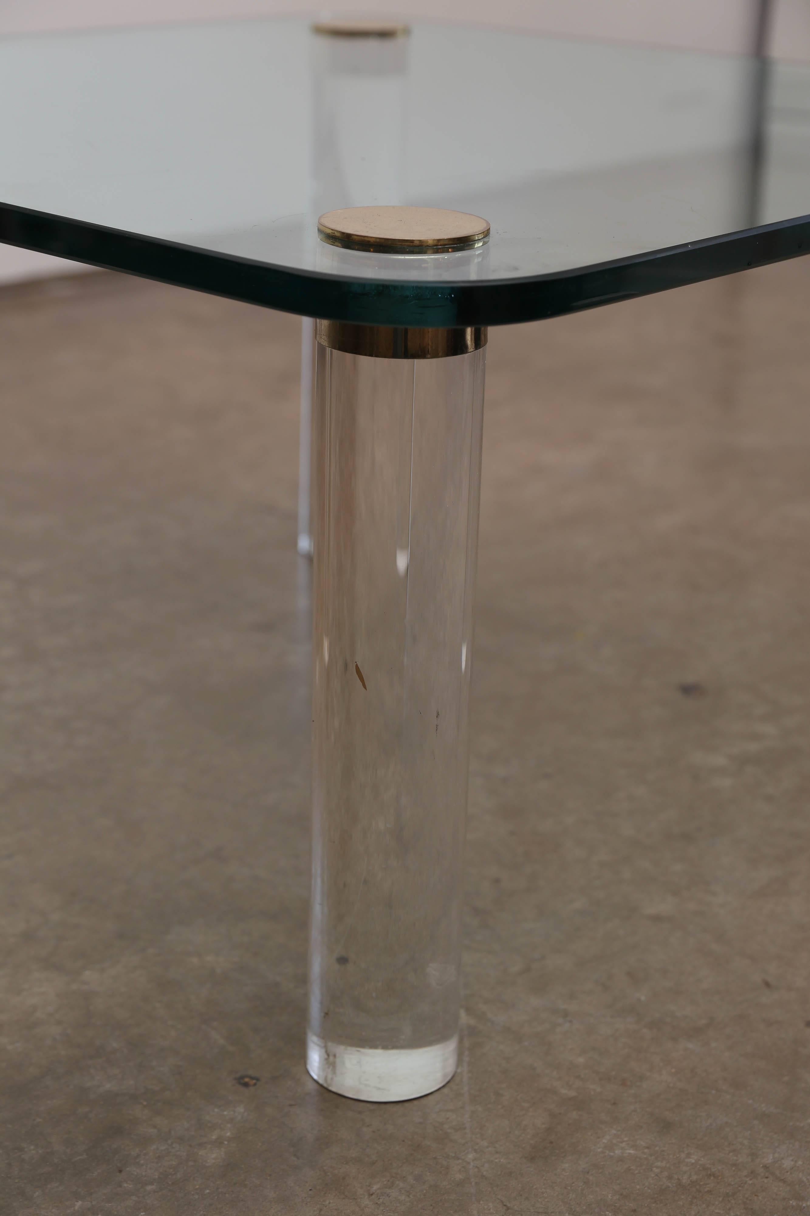 Offered is a vintage modern Pace small coffee, cocktail, side or occasional table. The top of the table is made from glass and the legs are thick Lucite with brass caps that screw in from the top side of the table.