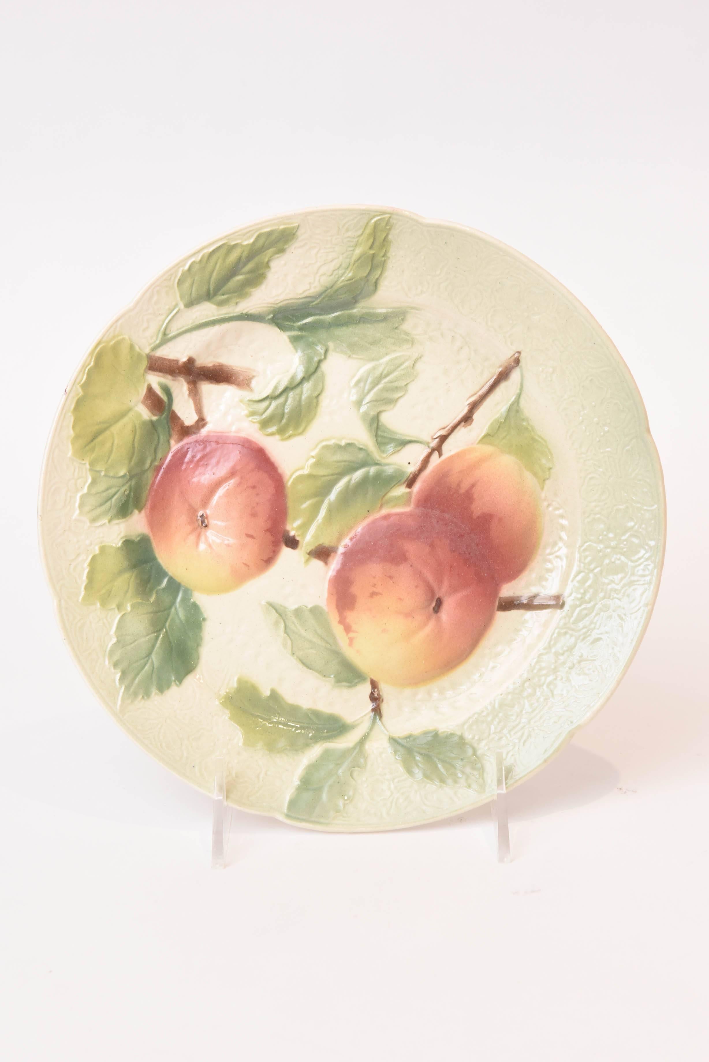 A charming set of two fruit plates featuring sculpted peaches with full leaf and branch details on a textured green back ground. Hall marked.
Please inquire for similar fruit plates as we stock much decorative Majolica.
