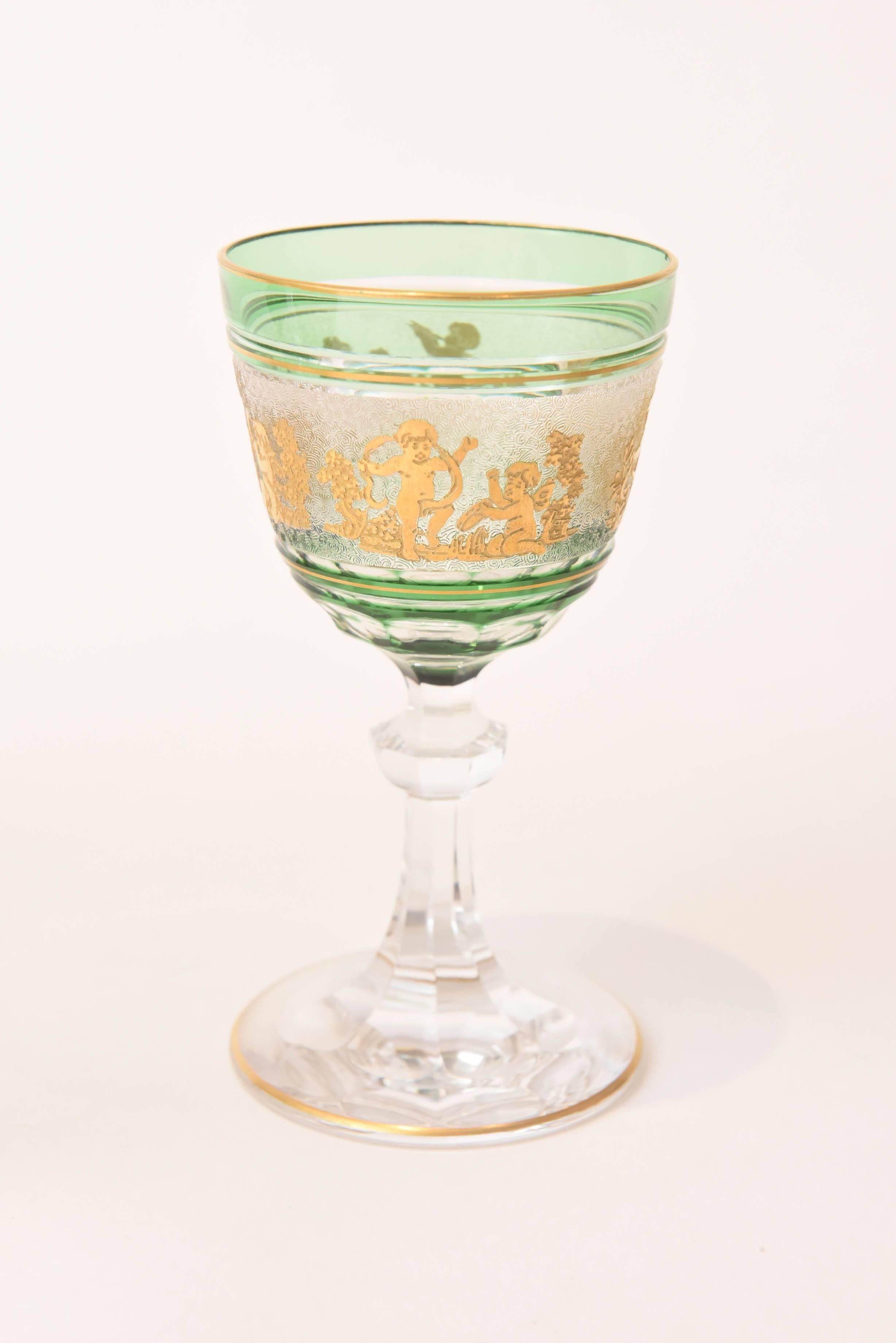 An exquisite set of wine glasses from the storied Belgium glass factory of Val St Lambert. These delightful wine glasses feature gilded cameo figures dancing along an elaborate acid etched background. They also have a beautiful emerald green cased