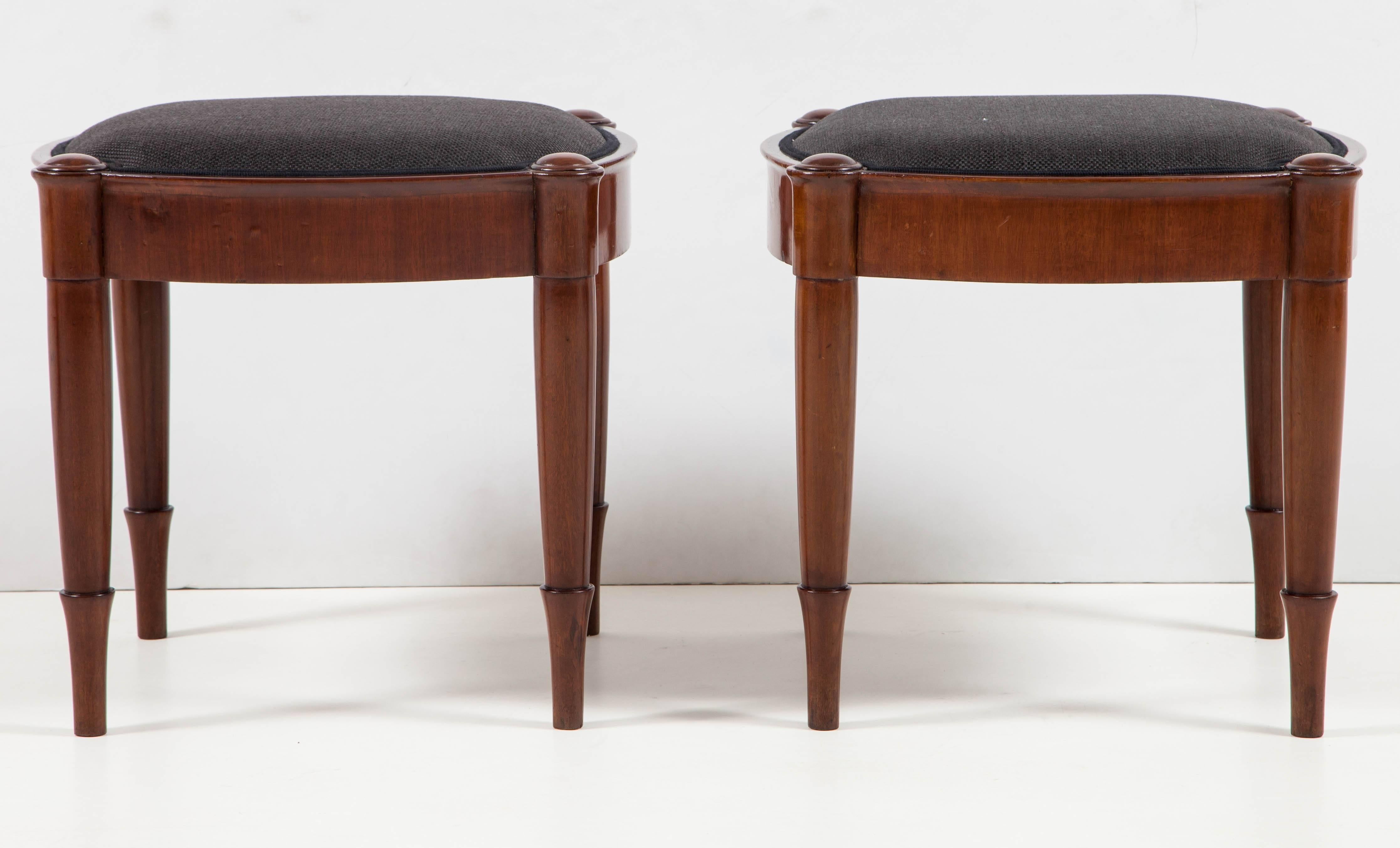 A pair of Danish neo-antique mahogany stools probably designed by the sculptor Herman Wilhelm Bissen, circa 1850s, with tight upholstered seats and a convex sided frame raised on a simple variation of the 