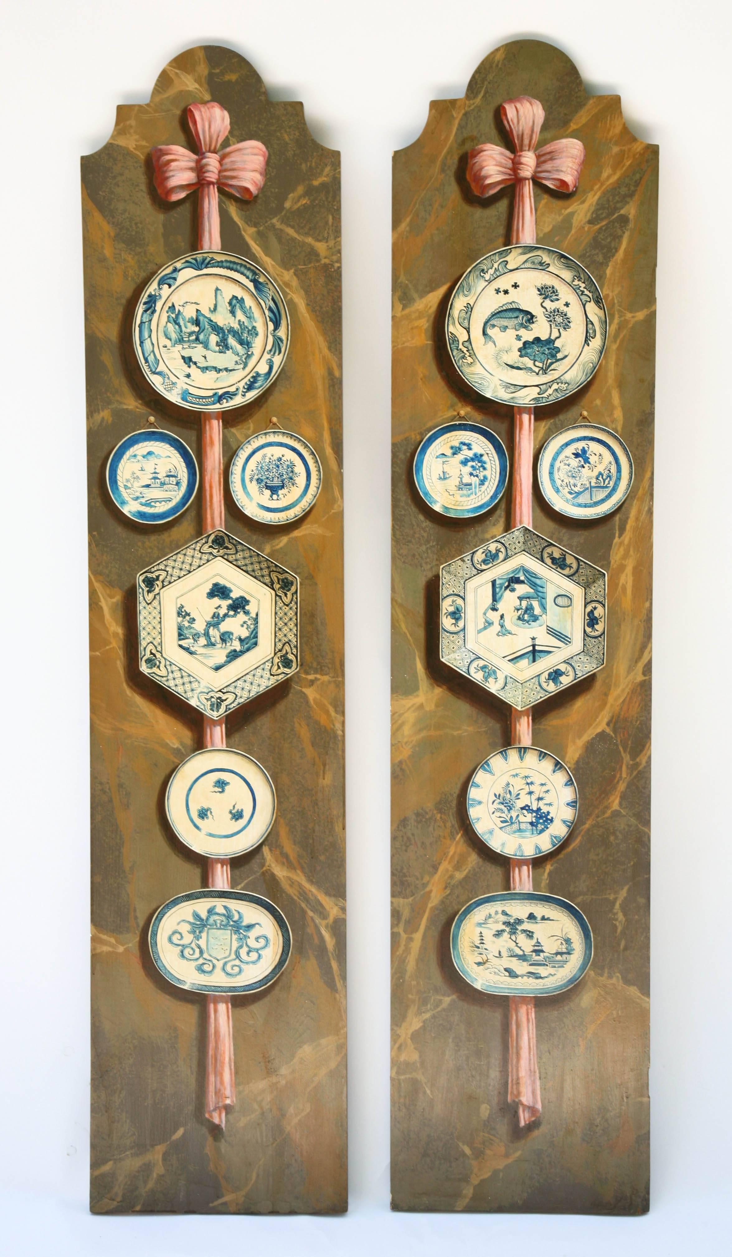 Pair of wooden panels, formerly cabinet doors, having rectangular forms with shaped pediments; each exquisitely hand-painted with a collection of blue and white platters and charges, hung from a ribbon, against a marbleized background.

Stock ID: