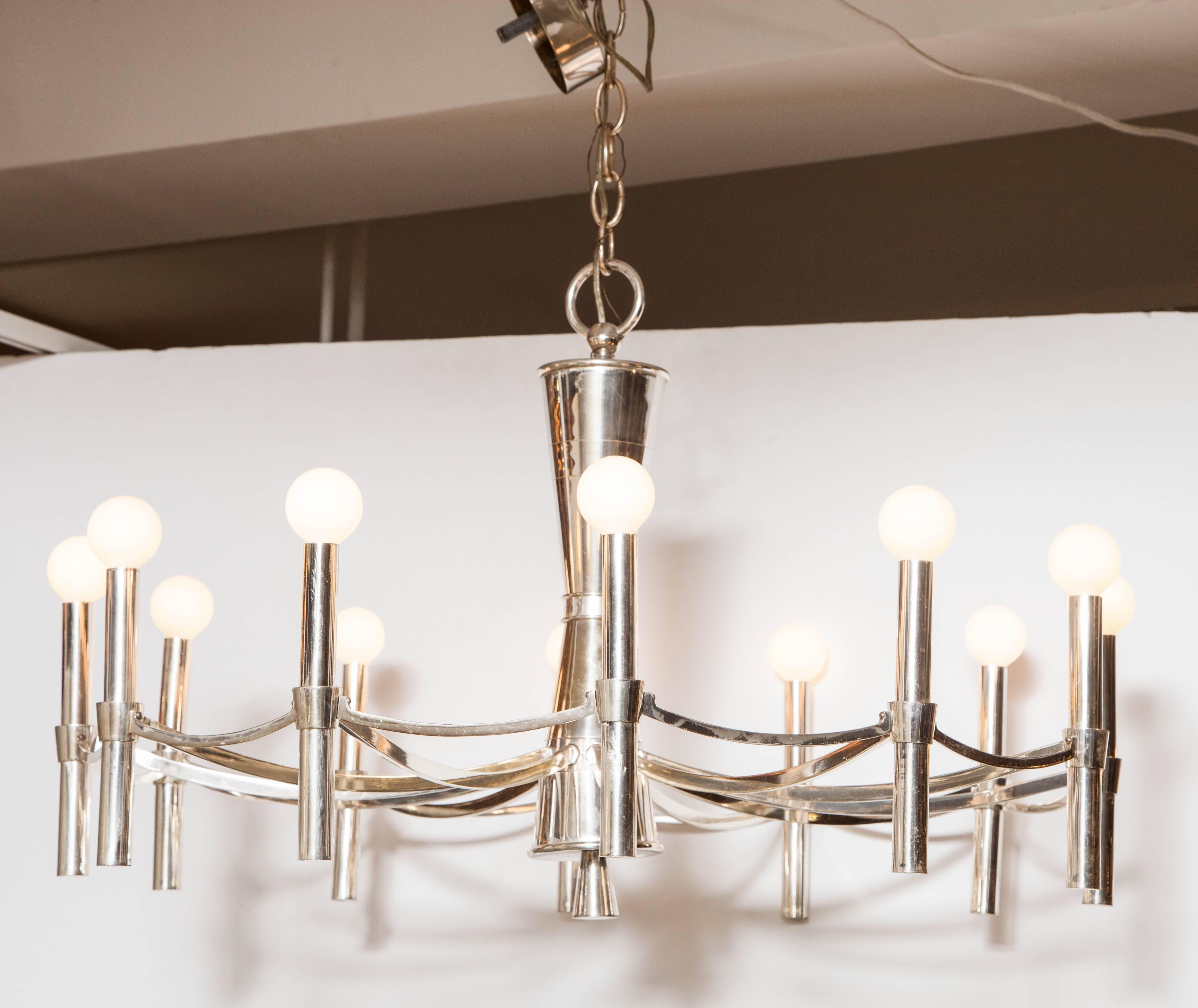 Early 1960s polished silver plate on brass chandelier as an elegantly detailed simple circle with struts connecting it to an hour-glass shaped central post. Rewired, but otherwise original; Presents well when installed; lacquered finish shows slight