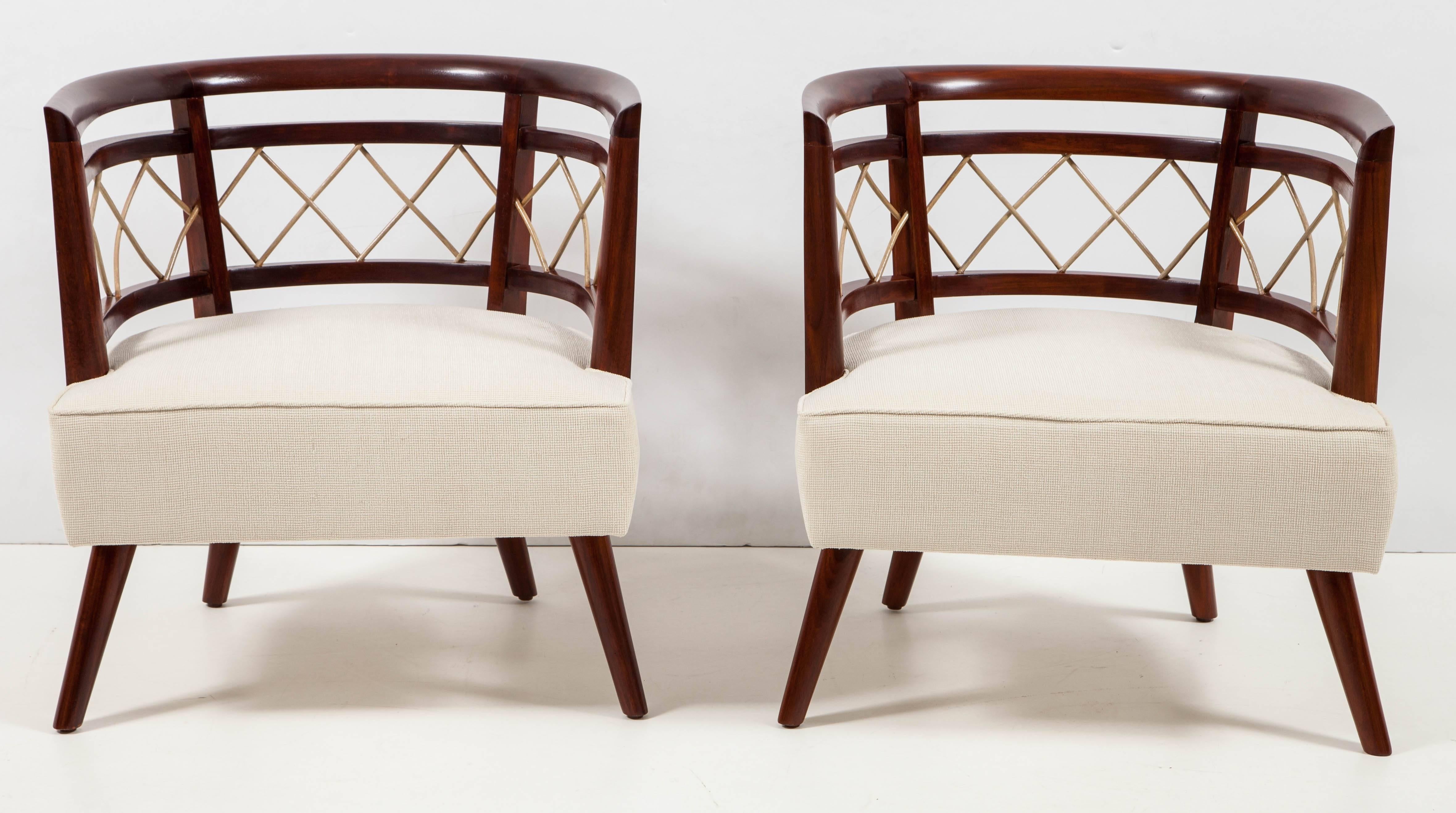 Small-scale 1950s lounge chairs with a strong visual punch. Polished European walnut frames enhances with a grillwork of rattan adding detail to the barrel arms and back. Newly refinished and reupholstered in natural linen bouclé́. 