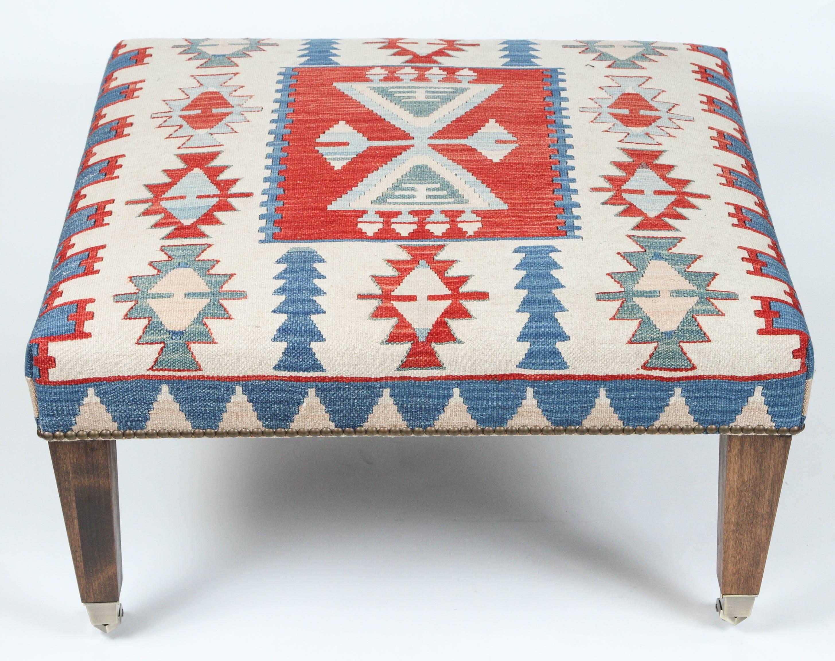 Vintage Kilim rug newly made into ottoman with walnut legs on casters and nailhead trim.