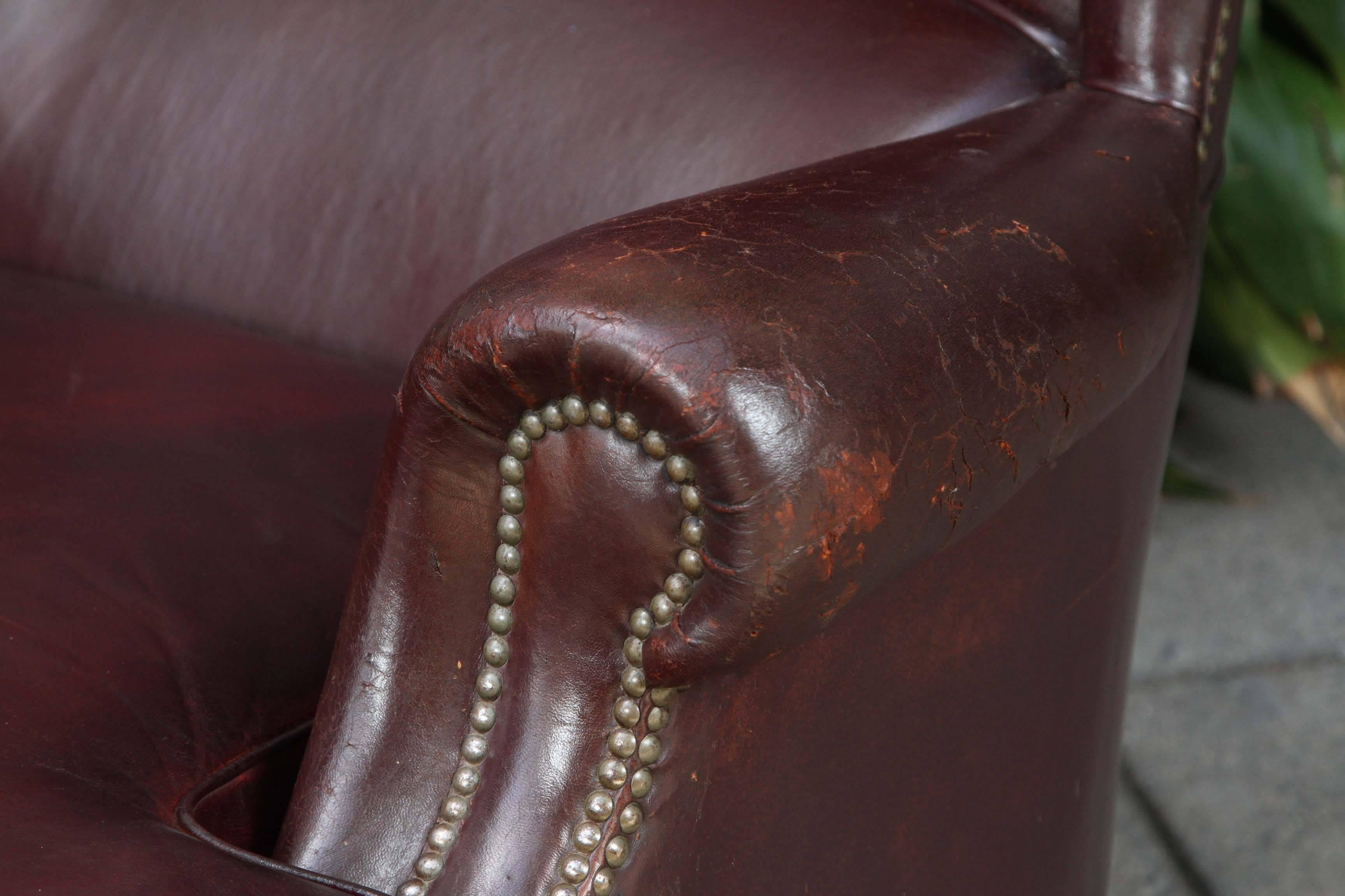 A late 19th century Italian later wingback chair on castors. The leather is a rich plum color with nice patina.