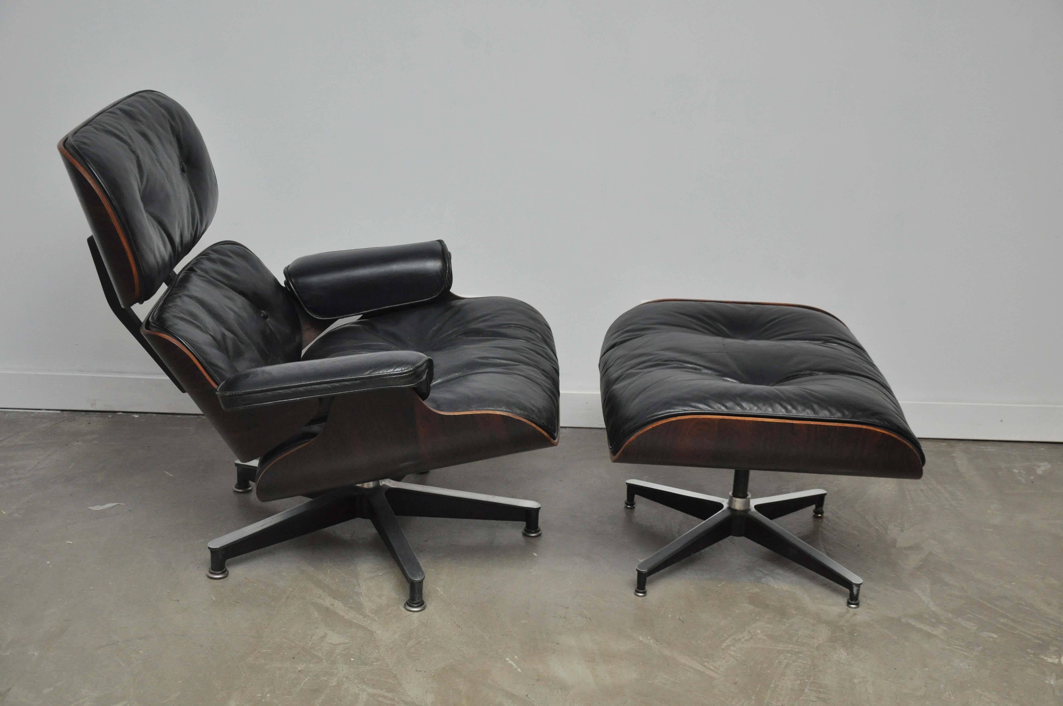 Rosewood lounge chair and ottoman designed by Charles and Ray Eames for Herman Miller. Original black leather and rosewood shells, all in excellent condition. Early model, circa 1950s.