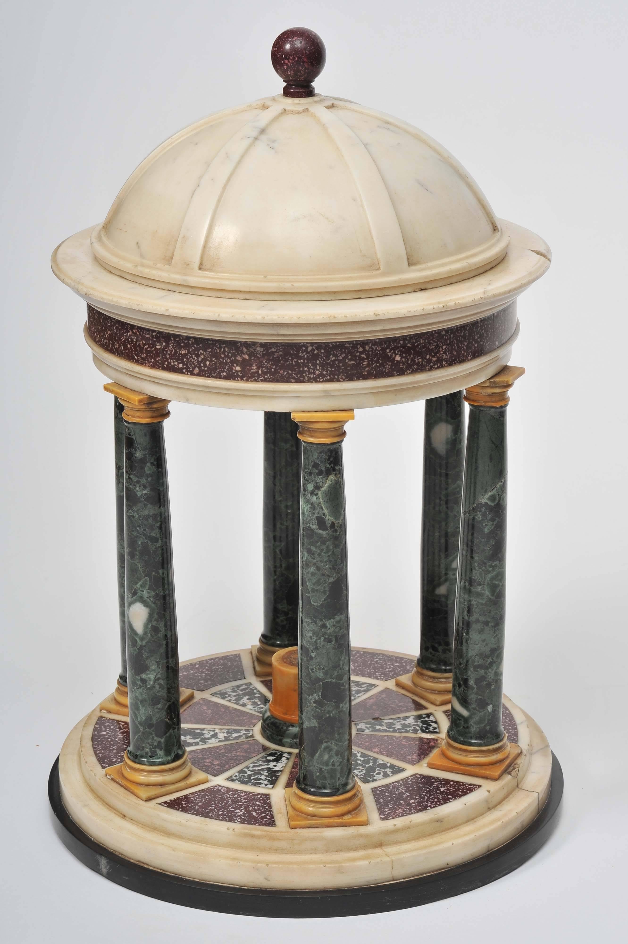 An early 19th century Grand Tour model of a classical temple. The removable statuary marble dome top capped by a Porphyry ball finial, above a classical structure of round form, the Porphyry frieze above Doric columns in Verde Antico, with Giallo