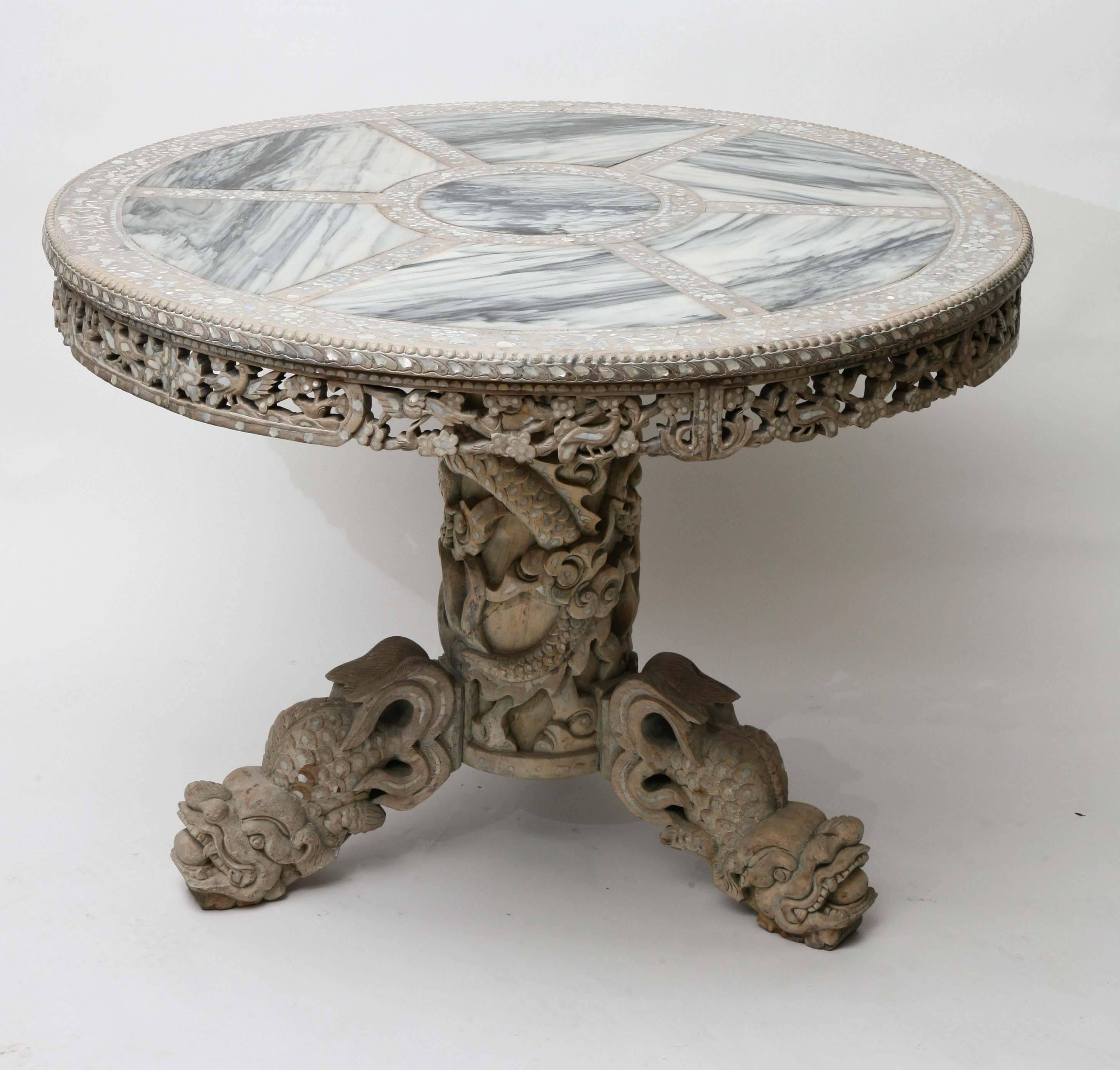 Lovely late 19th-early 20th century Chinese center table. Finely carved whitewashed hardwood with extensive mother-of-pearl inlays and segmented marble top. From the estate of noted interior designer, Thomas Britt. Mortise and tenon legs and top