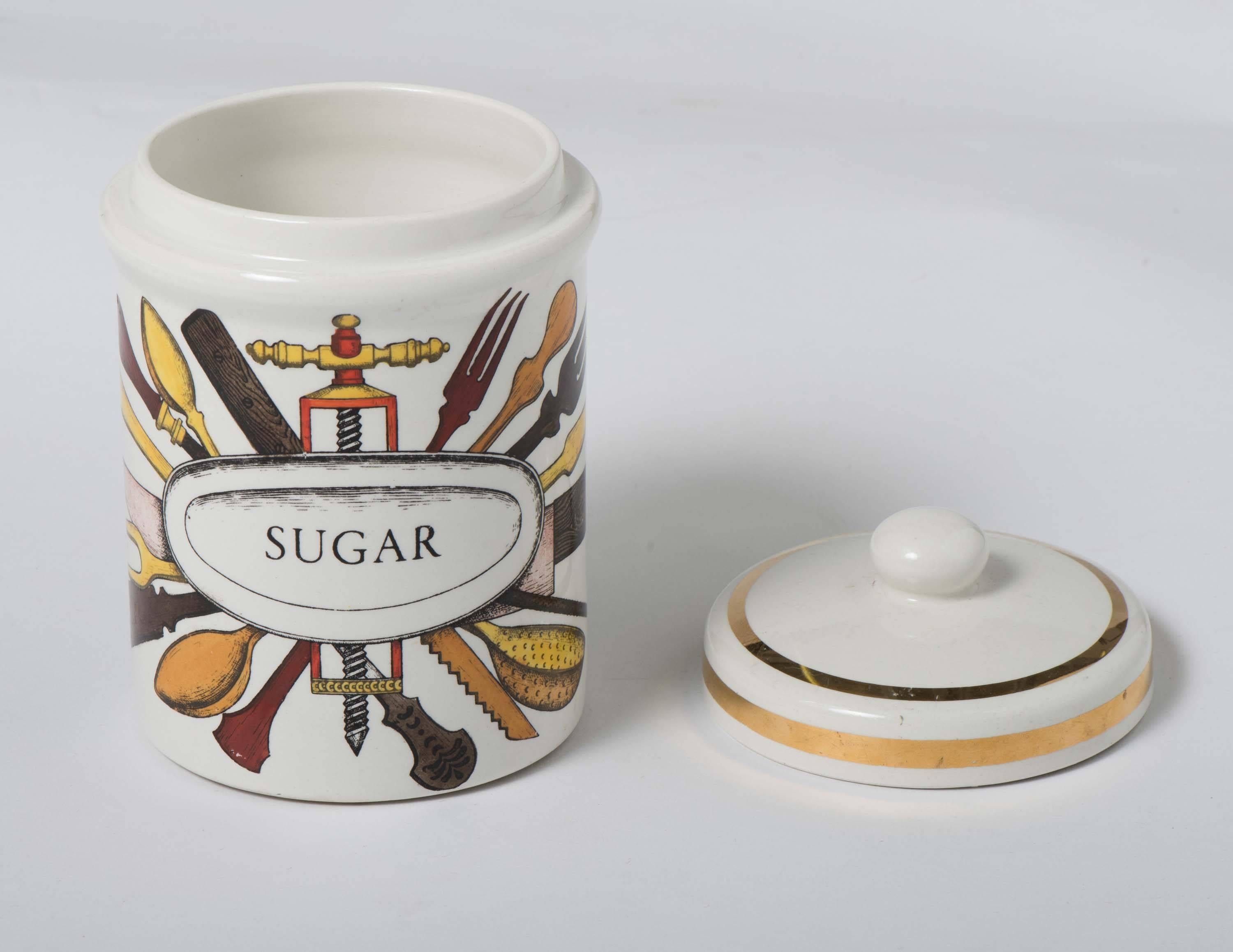 An early porcelain jar with cover by Piero Fornasetti.
“Sugar”.
Lithographically printed and hand-painted.
Mark to base,
Italy, circa 1960.
Measures: 17.5 cm high x 12 cm diameter.
    