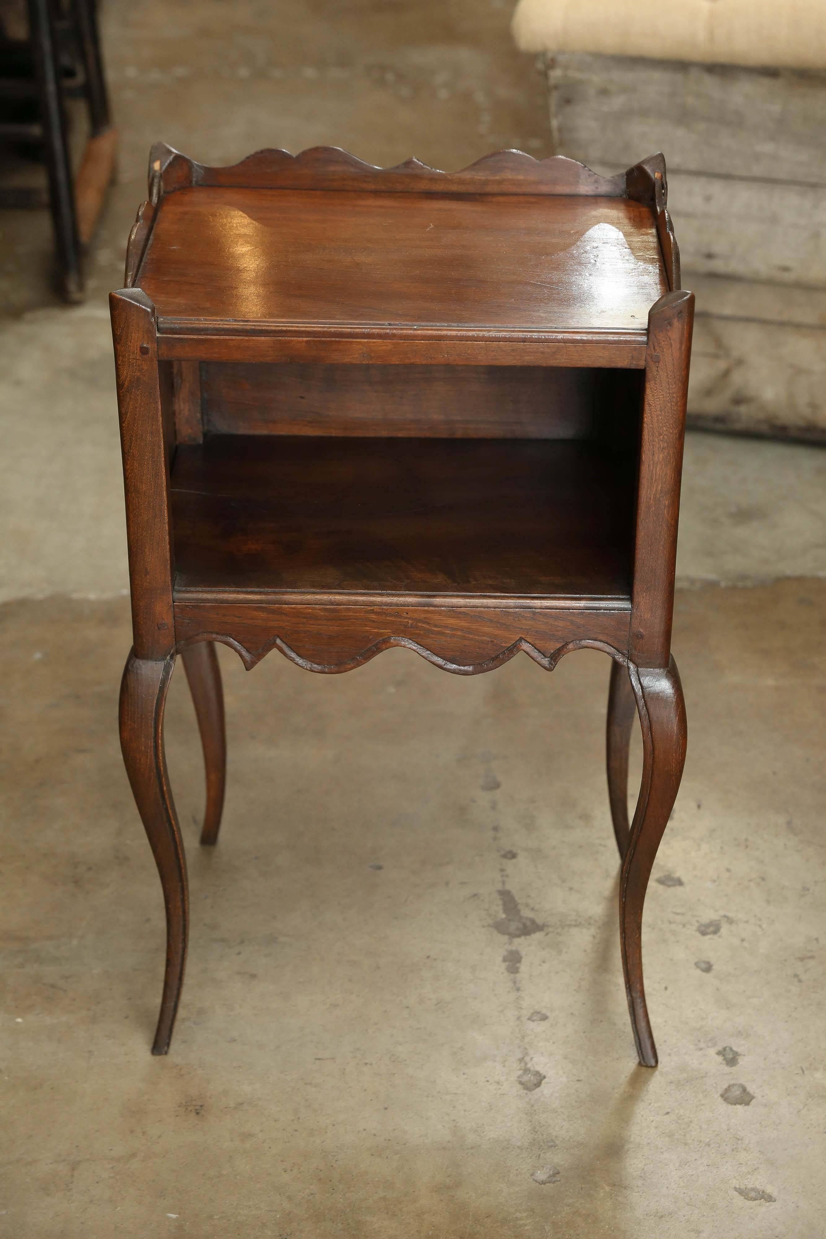 Small French bedside table with open shelf. In the center of each side there is a carved heart. Table sits on graceful cabriole legs. Apron is carved on all four sides as well as the 3/4 perimeter around the top of the table.