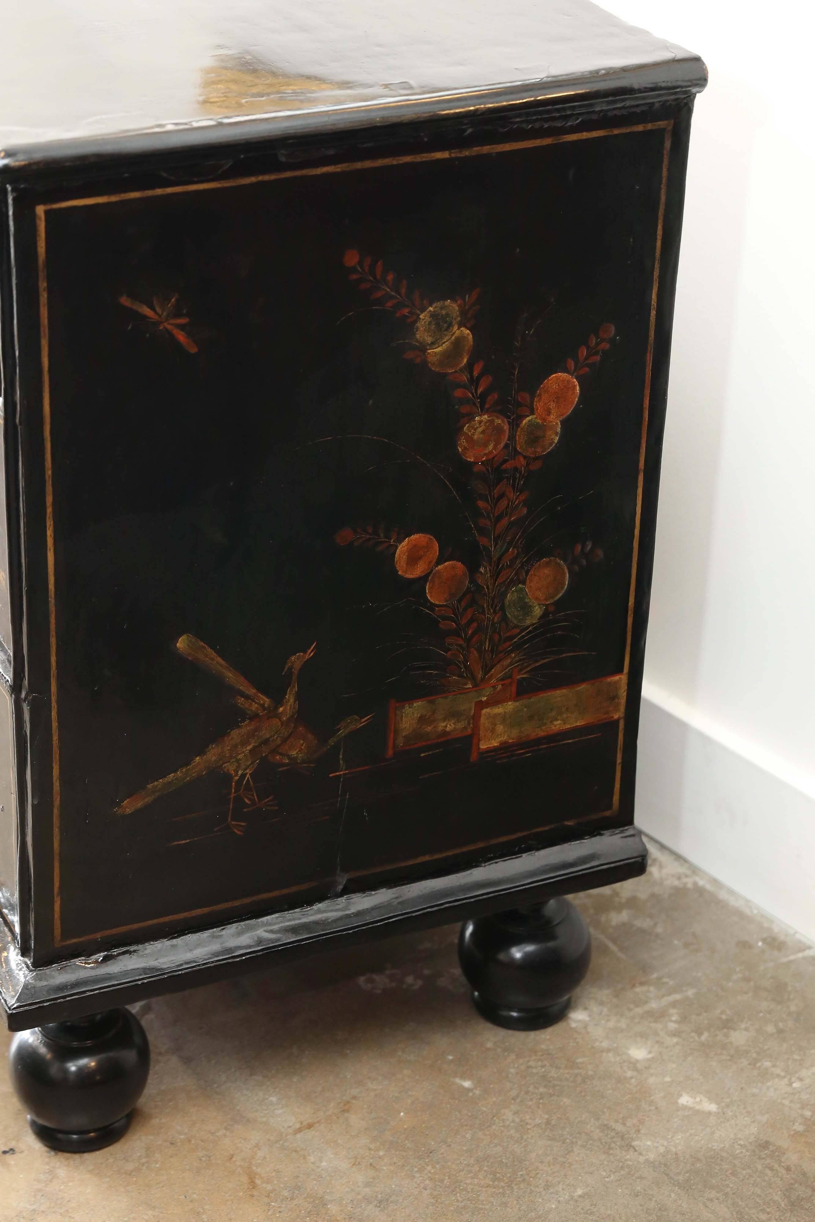18th century English chinoiserie chest with two short drawers and two larger drawers on bun feet. Beautifully detailed raised gilt and color used to depict flowers, animals, people and scenes on a black lacquered background. Each drawer has a