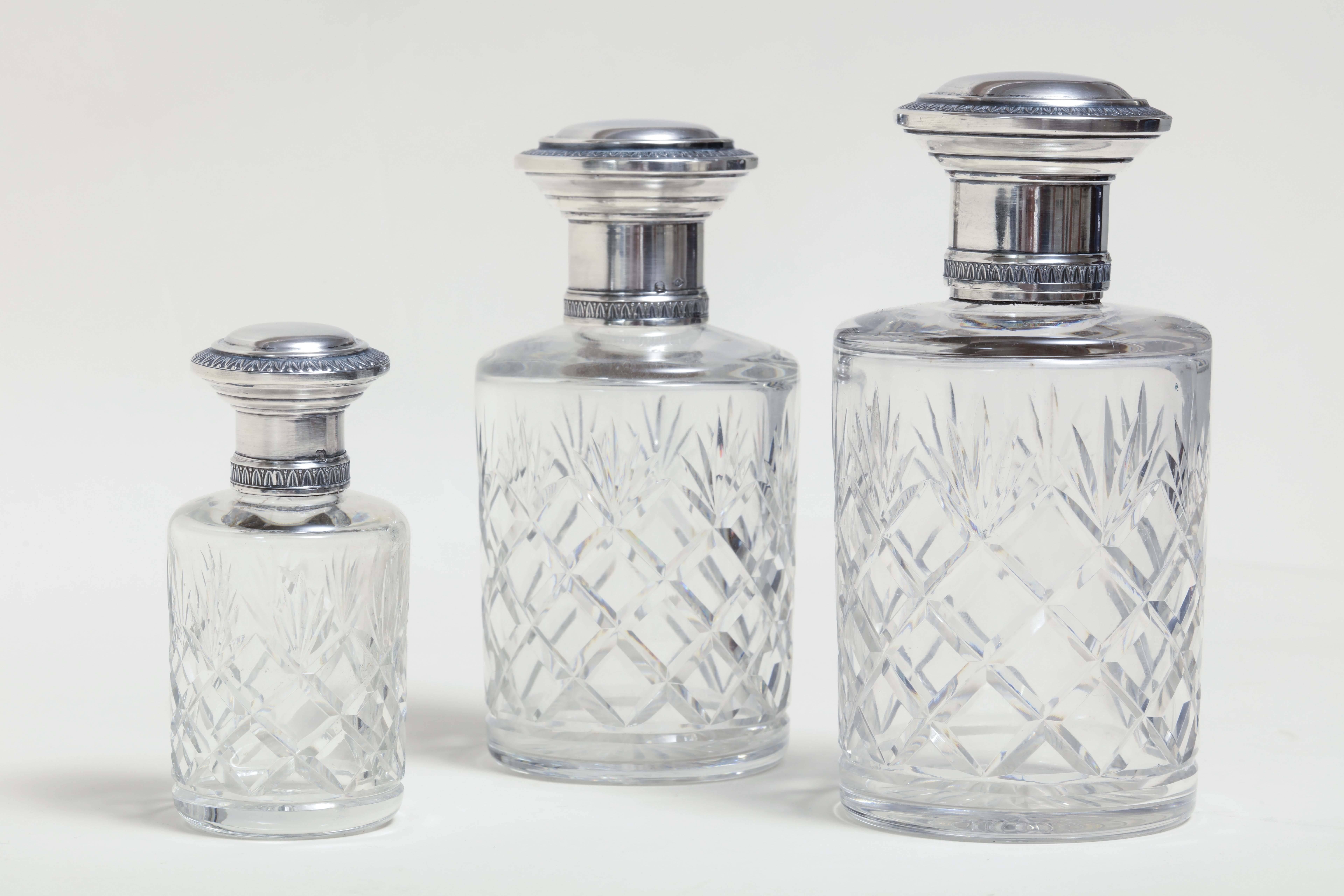 With carve crystal bodies, glass stoppers for the two larger flacons and sterling silver tops.

Measures: 6” high; 2 7/8” wide,
5 5/8” high; 2 ¾” wide,
4” high; 1 7/8” wide.

Impressed with Minerve for 950 silver/ maker’s poincon.
 