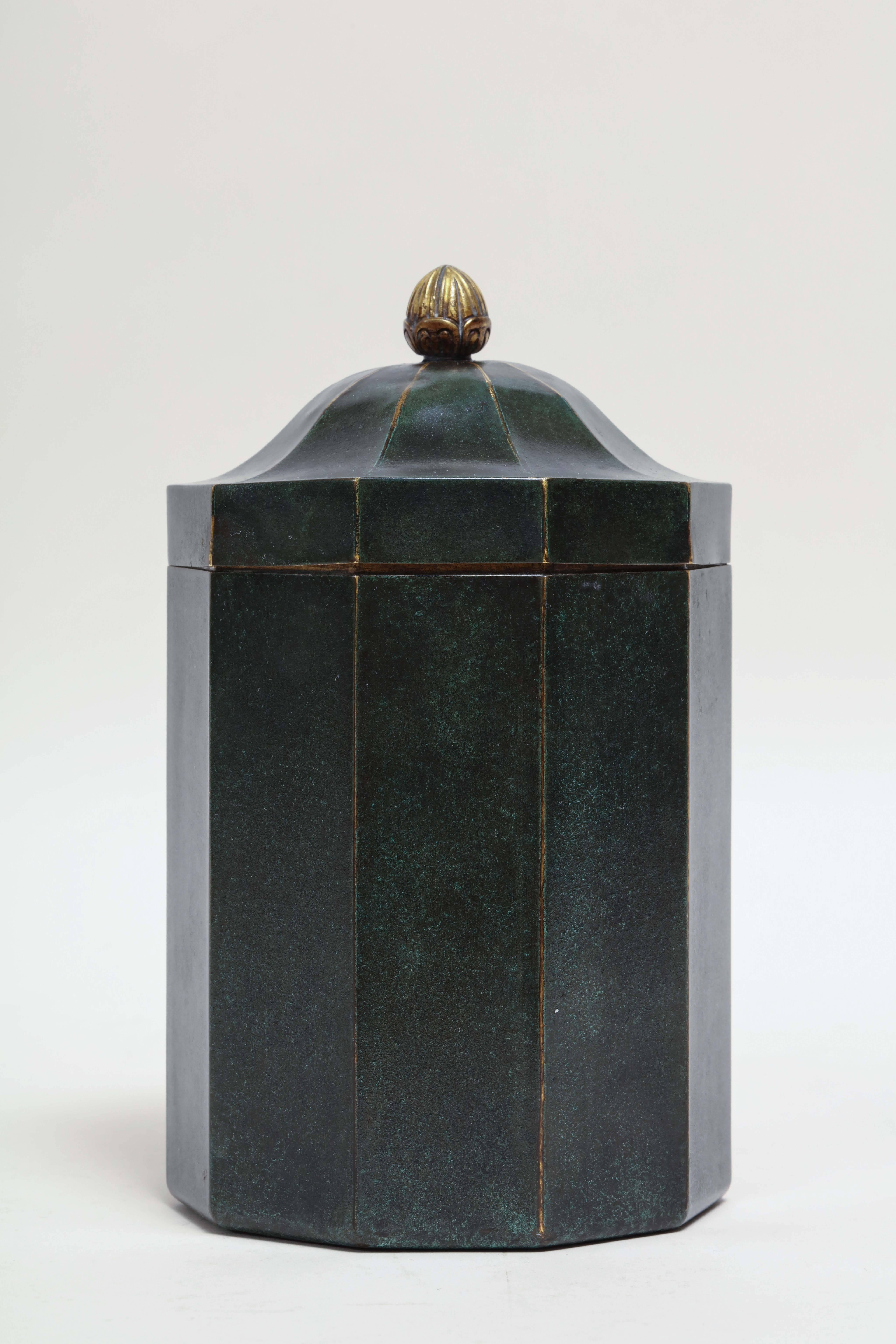 Model created for the Exposition des Arts Decoratifs, Paris, 1925.

Ten-sided brass box with green and gold patina.

With a lid with a gilded stylized grain-shaped finial and gilded interior.
Impressed CHRISTOFLE/ B27/ F.

Literature:
“le