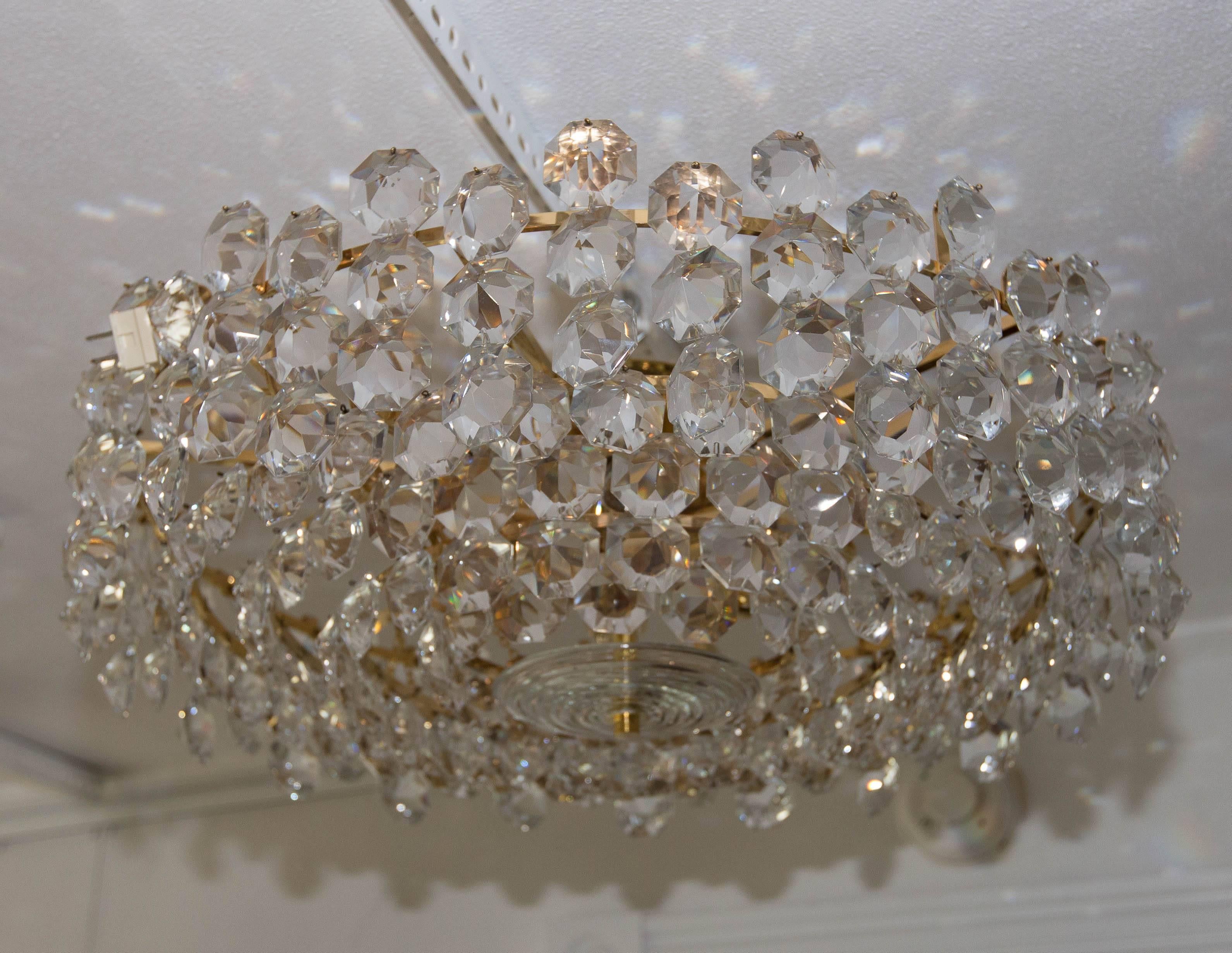 Tiered brass and facet cut-glass element chandelier.