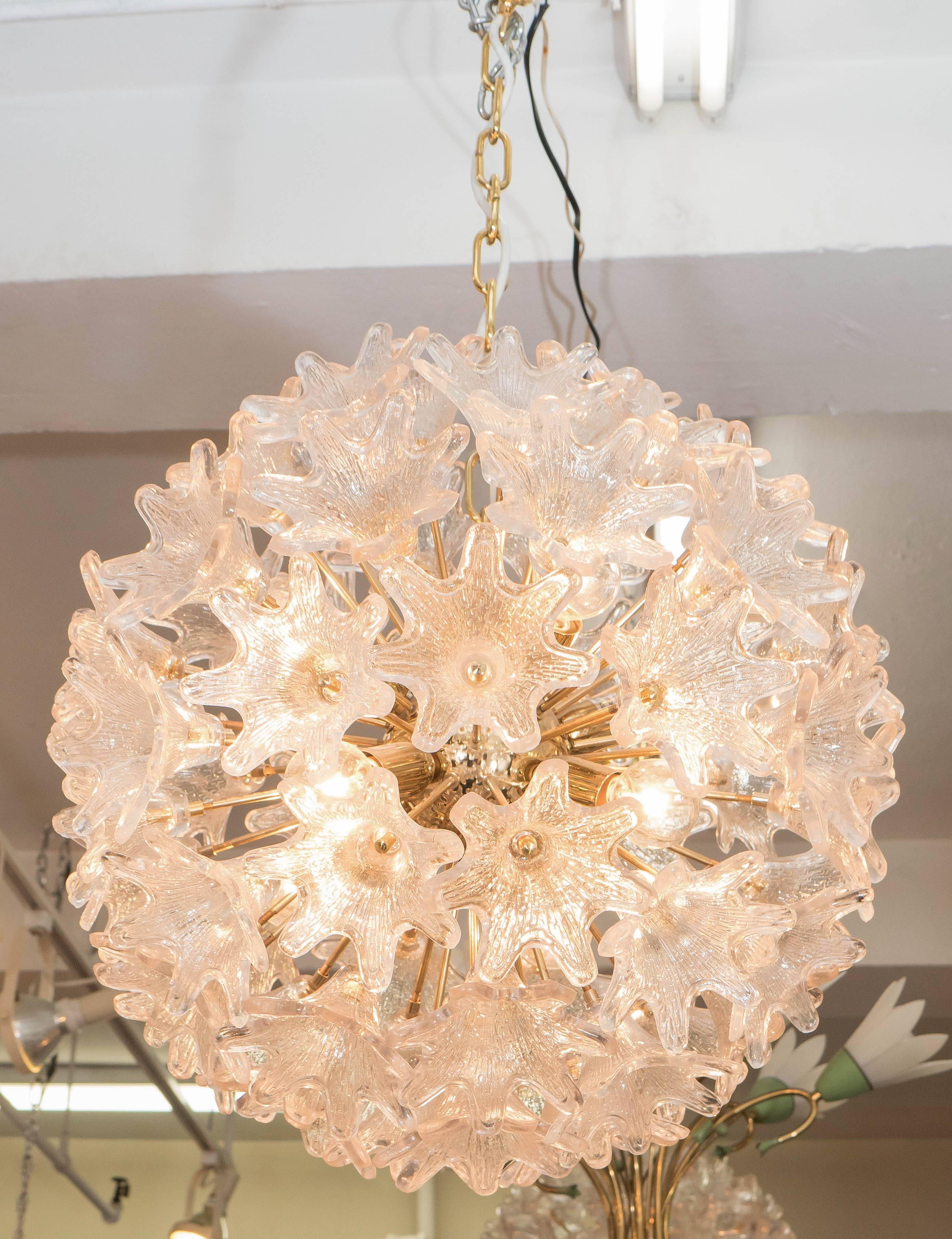 An Italian circa 1960s Sputnik chandelier, with polished brass nucleus and arms, terminating in sockets and textured Murano glass flowers. This light fixture is in very good condition, consistent with age and use; minimal presence of wear to brass.