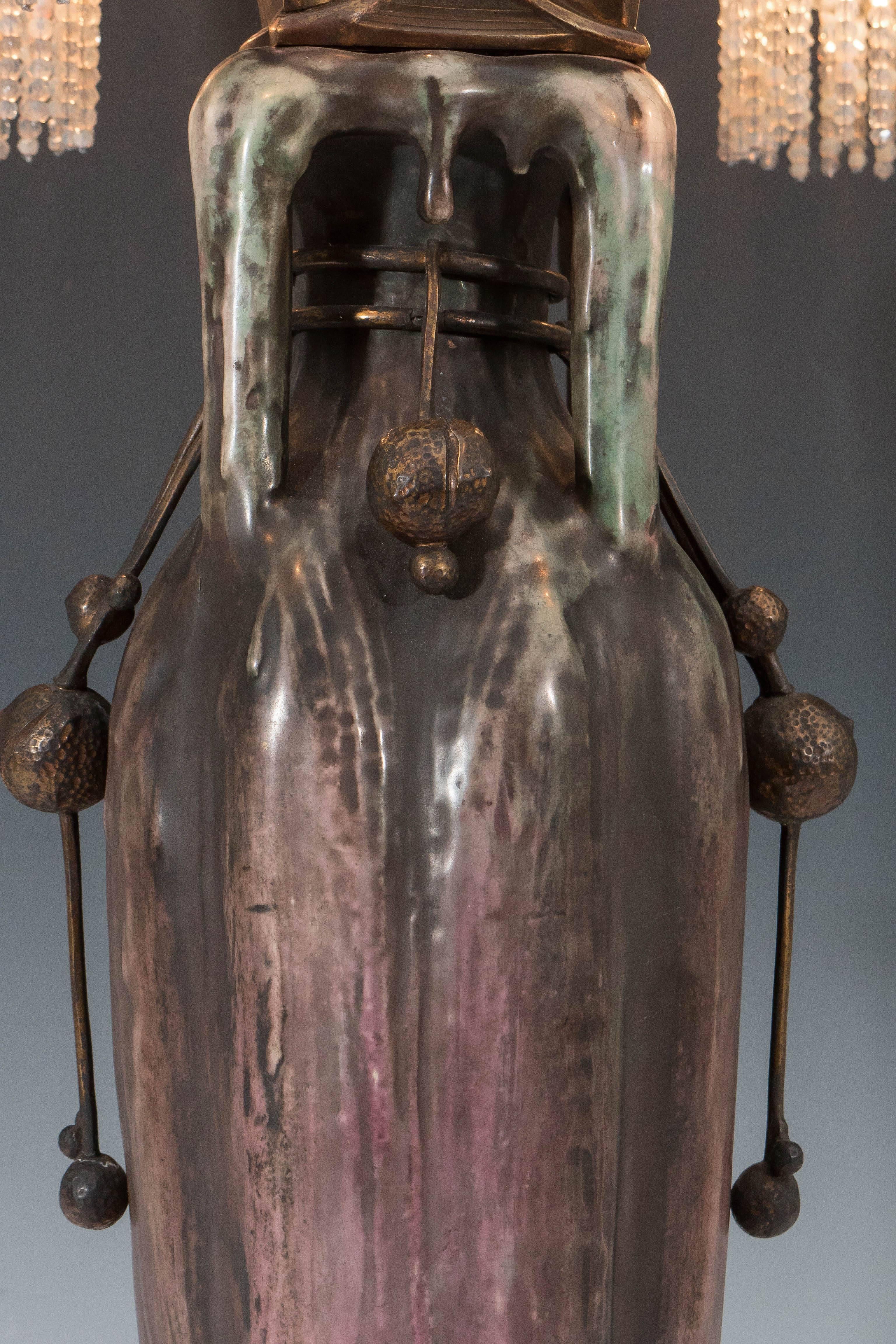 Cette étonnante lampe Art nouveau autrichienne comprend un vase en poterie de la série EDDA par Amphora comme base, monté avec des éléments en bronze moulés et faits à la main, garnis de perles de verre et de cristal. Daté de 1901, ce vase au design