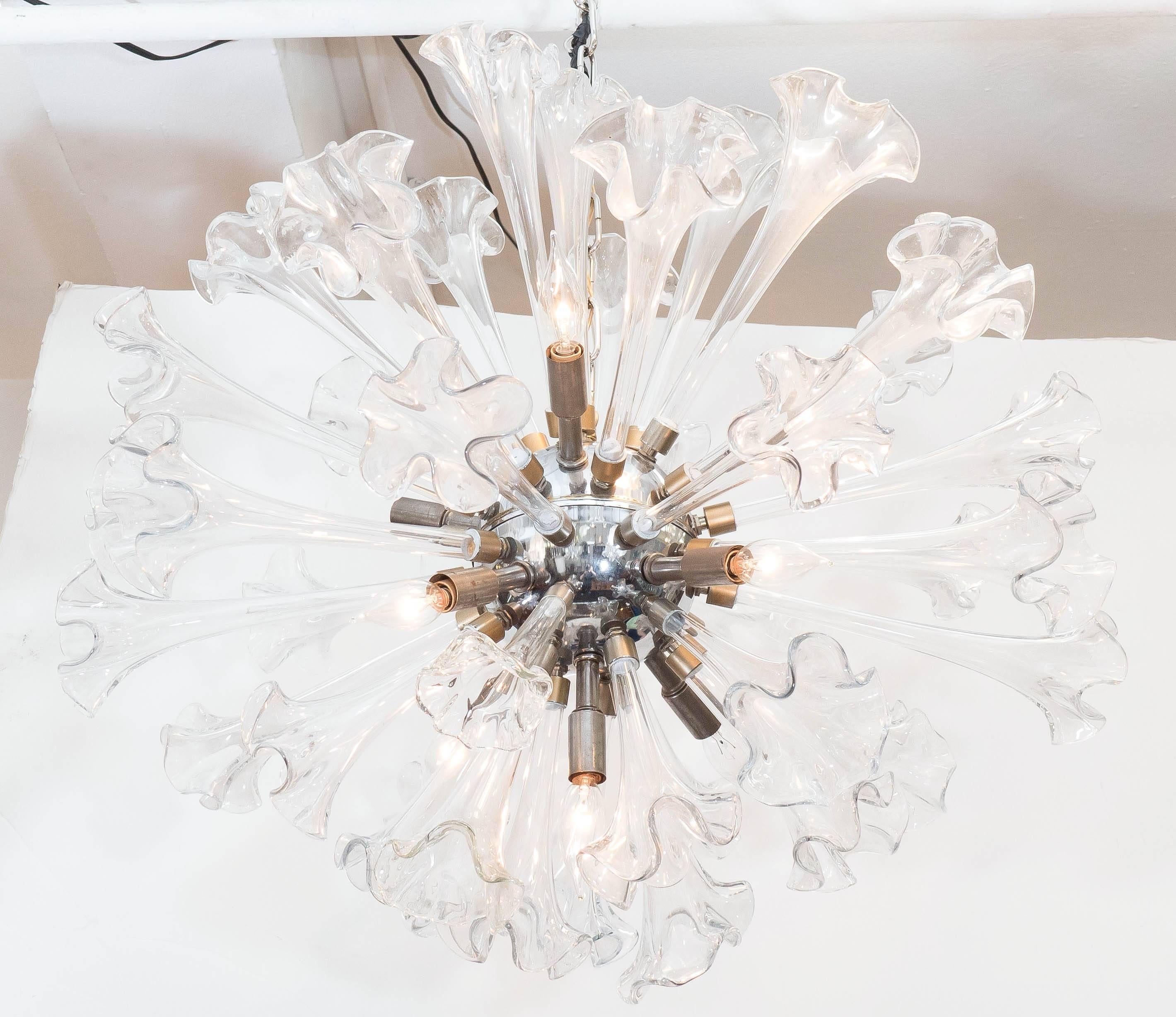 Sputnik chandelier, produced circa 1960s, features lengthy Murano glass ruffled trumpet lilies, surrounding a metal nucleus. Wiring to US standard. Very good vintage condition, with age appropriate wear to metal hardware.