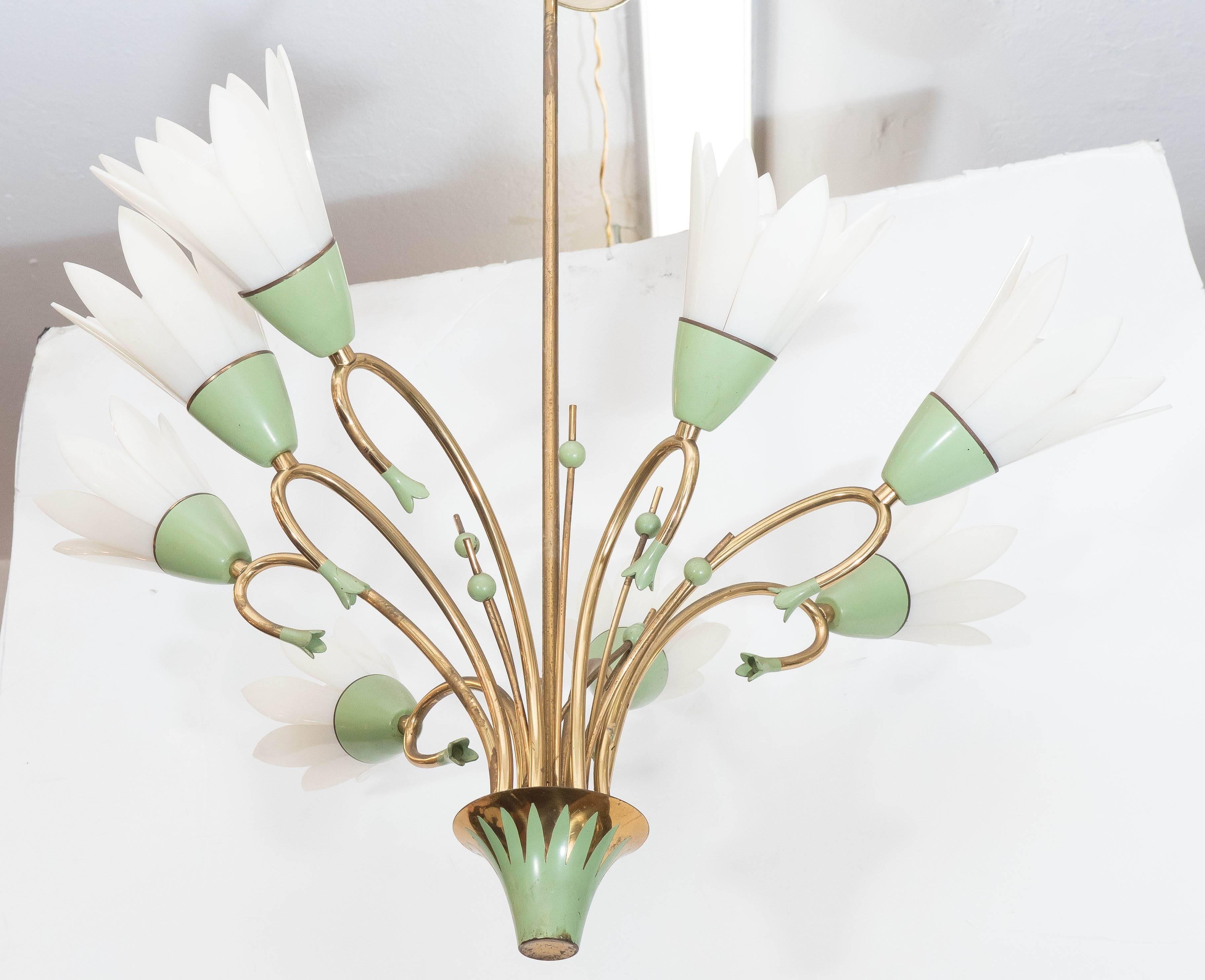 A whimsical circa 1960s chandelier, in brass with pale green enamel detail, with conical base, supporting curved stems and arms, eight with sockets and petal form shades. Requires medium base bulbs. This light fixture remains in very good vintage