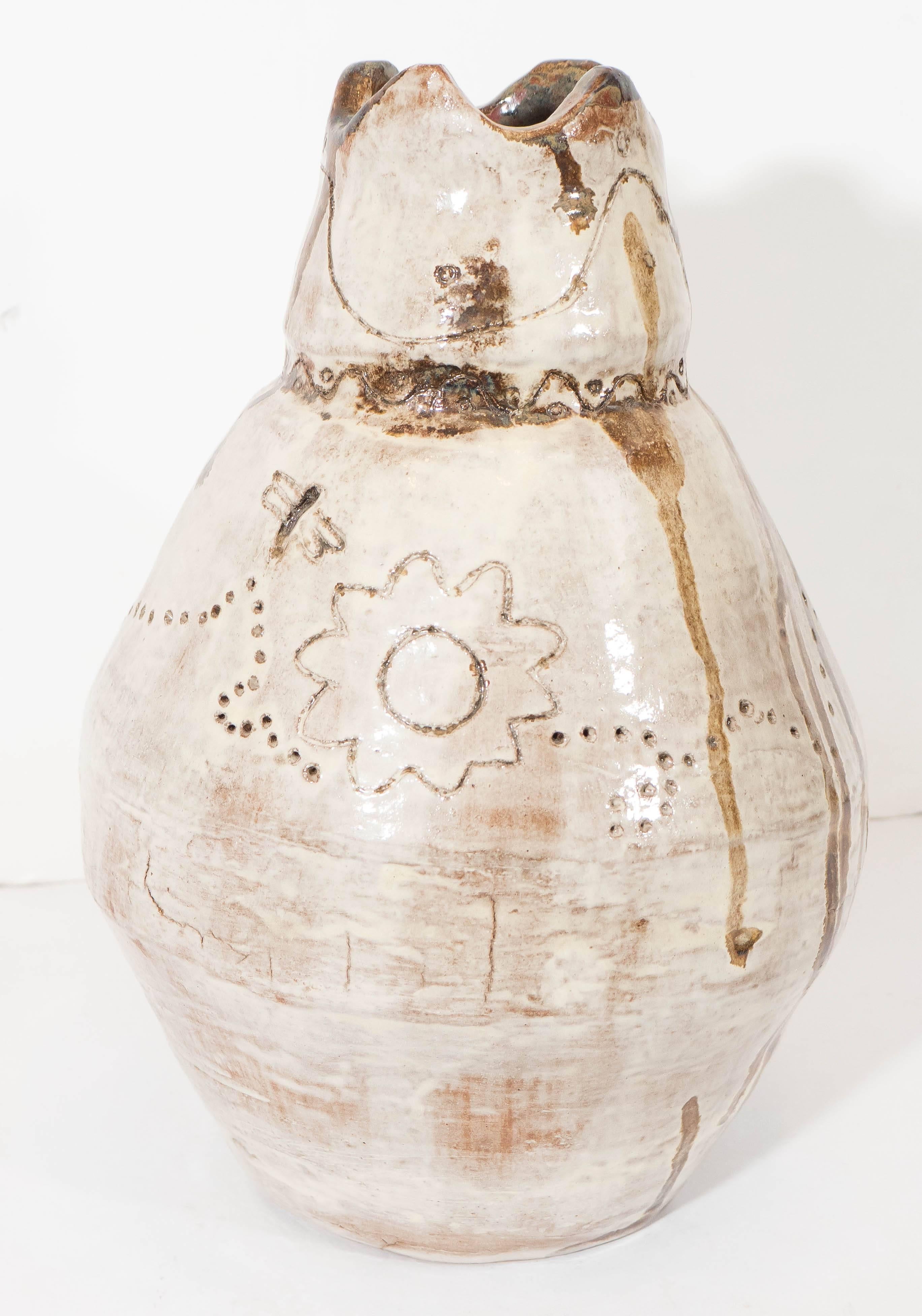 A hand-thrown gourd shaped vase, in glazed ceramic with incised details, rippled pattern to the neck, above details of bee and flower to the body. Despite presence of wear and cracking to base, the vase remains in good overall condition.