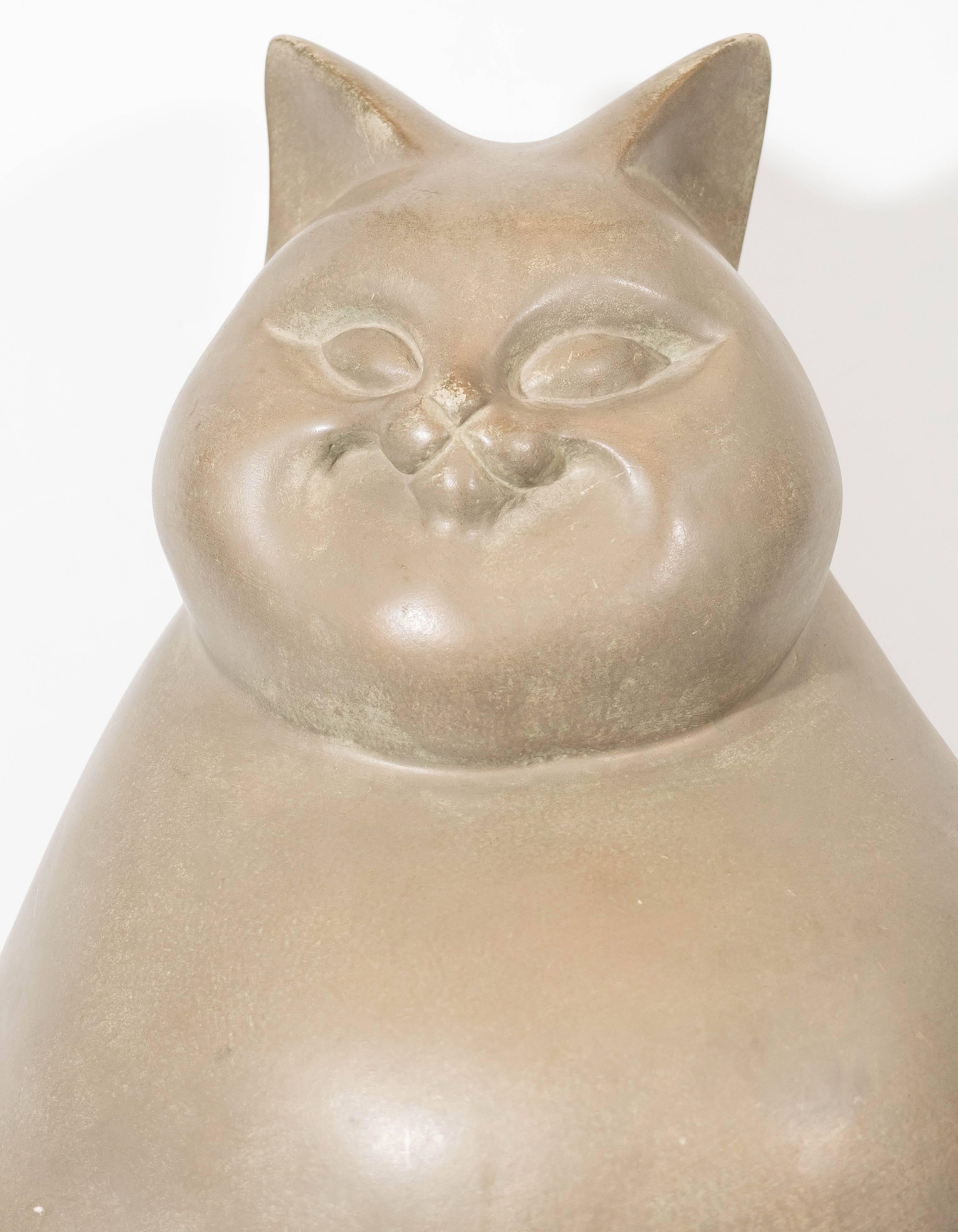 This modern ceramic sculpture of a grinning fat cat derives much inspiration from artist Fernando Botero (b. 1932), best known for portraying heavy-set figures and animals in his works of art. The sculpture's clean lines and minimal details marries