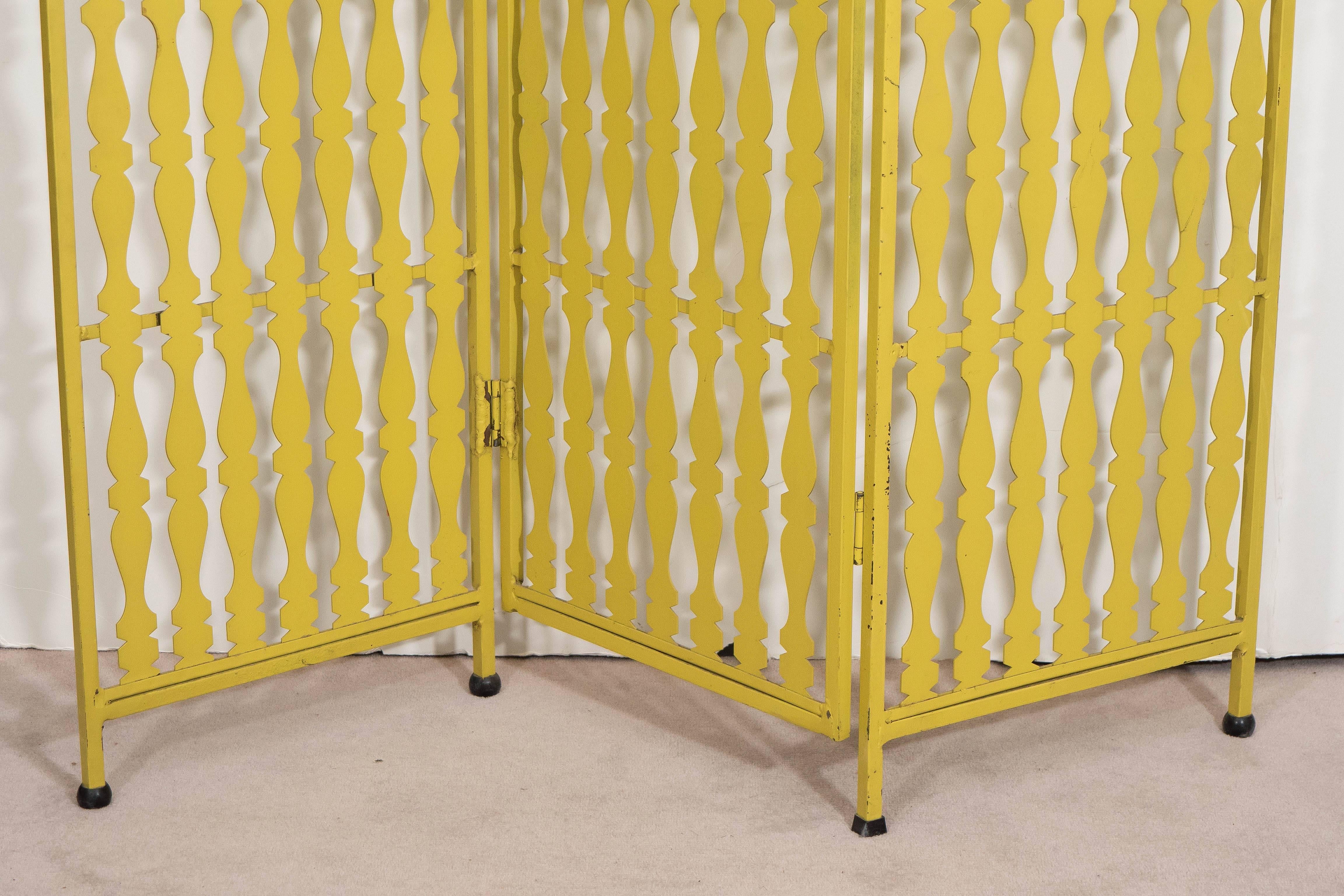 Paravent et séparateur de pièce du designer Arthur Umanoff, produit vers les années 1950, en métal soudé et émaillé avec trois panneaux pliants, composé de rails balustres découpés et de pieds et fleurons en forme de boule. Cette pièce reste en bon