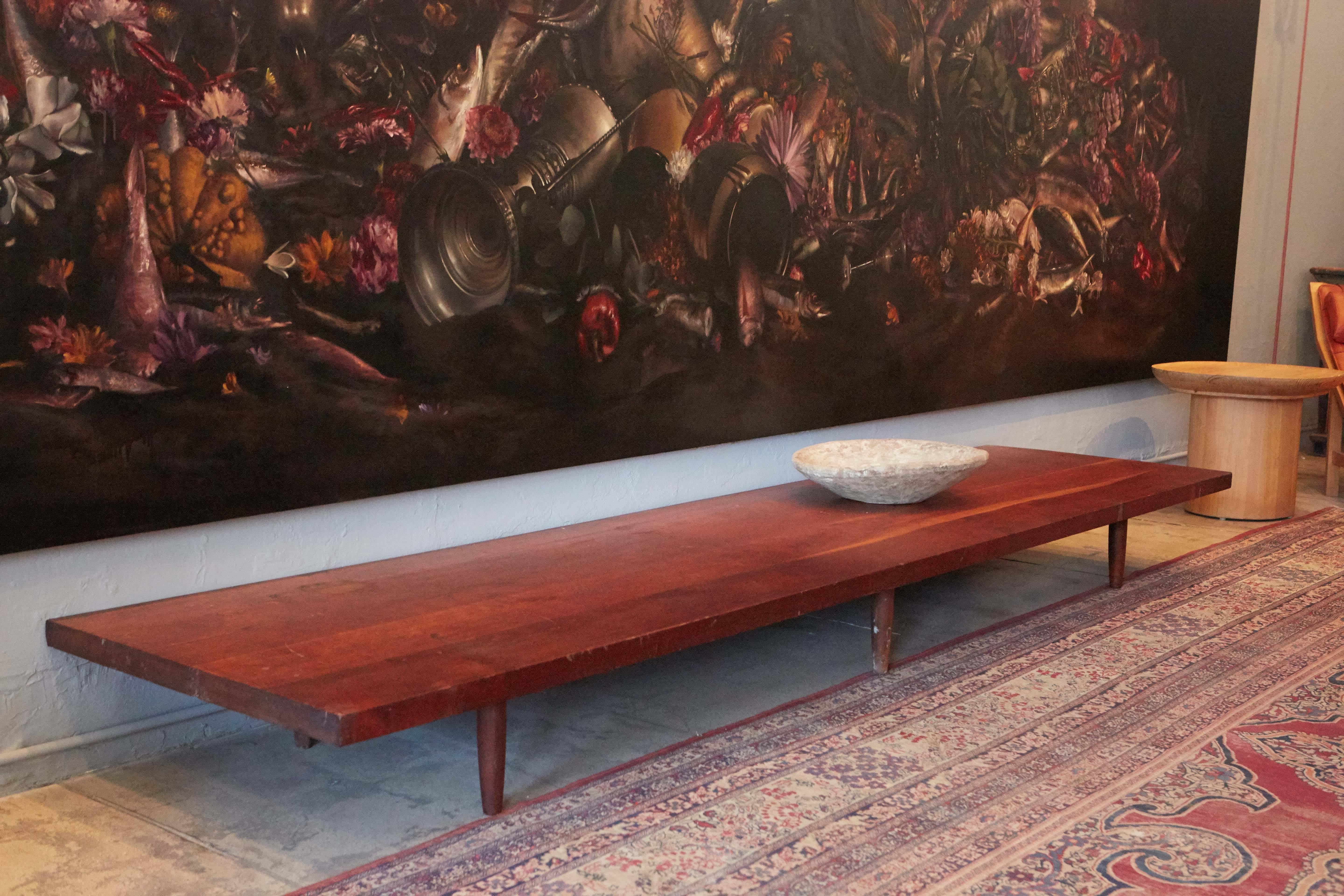 A beautiful long low cherrywood bench or table by George Nakashima.