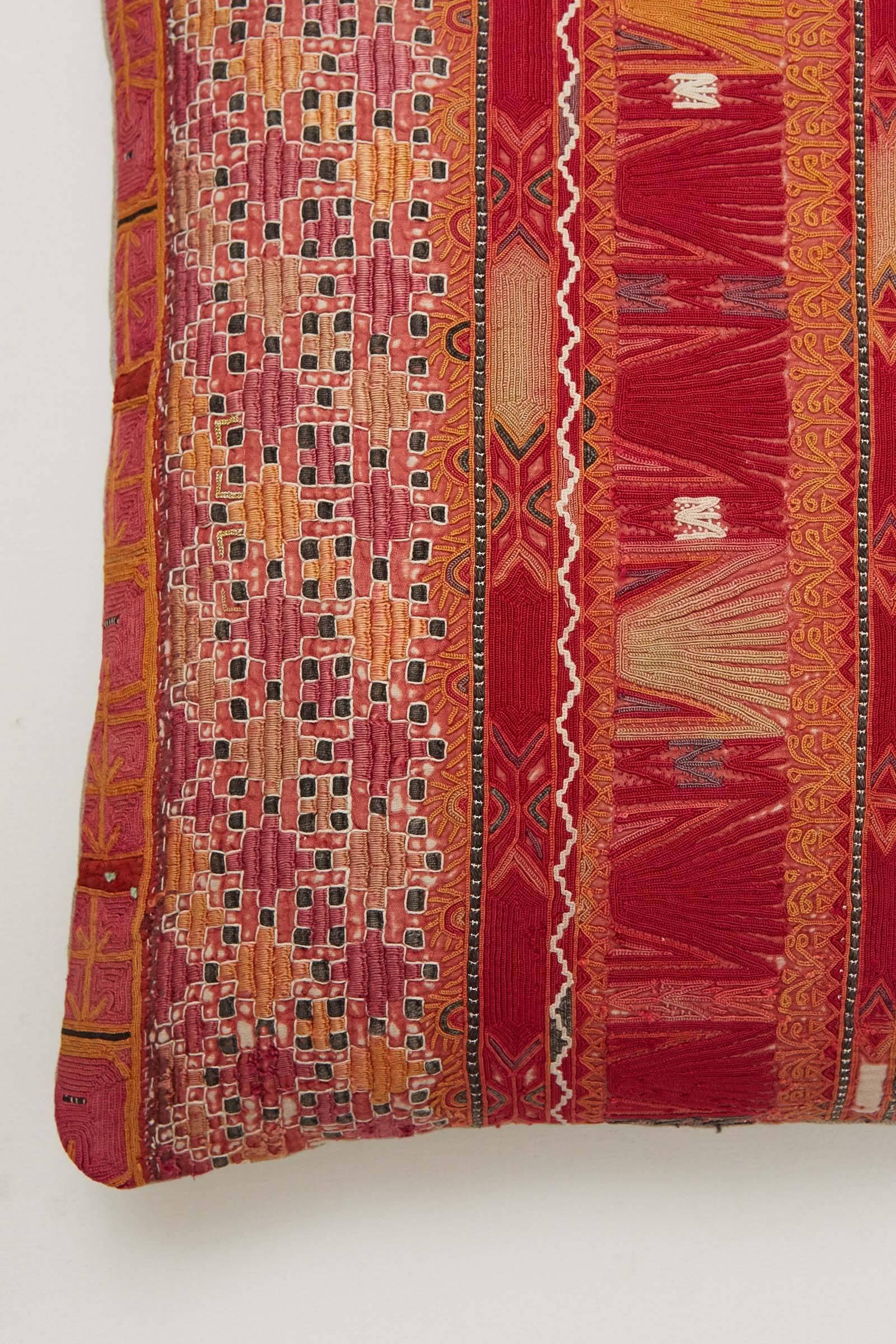 Intricately embroidered silk on cotton vintage textile. Measures: 17 x 19. Pink, orange, black, celadon. Sleeve fragment from a Pashtun tribal tunic. Natural linen back. Invisible zipper. Feather and down fill.
 