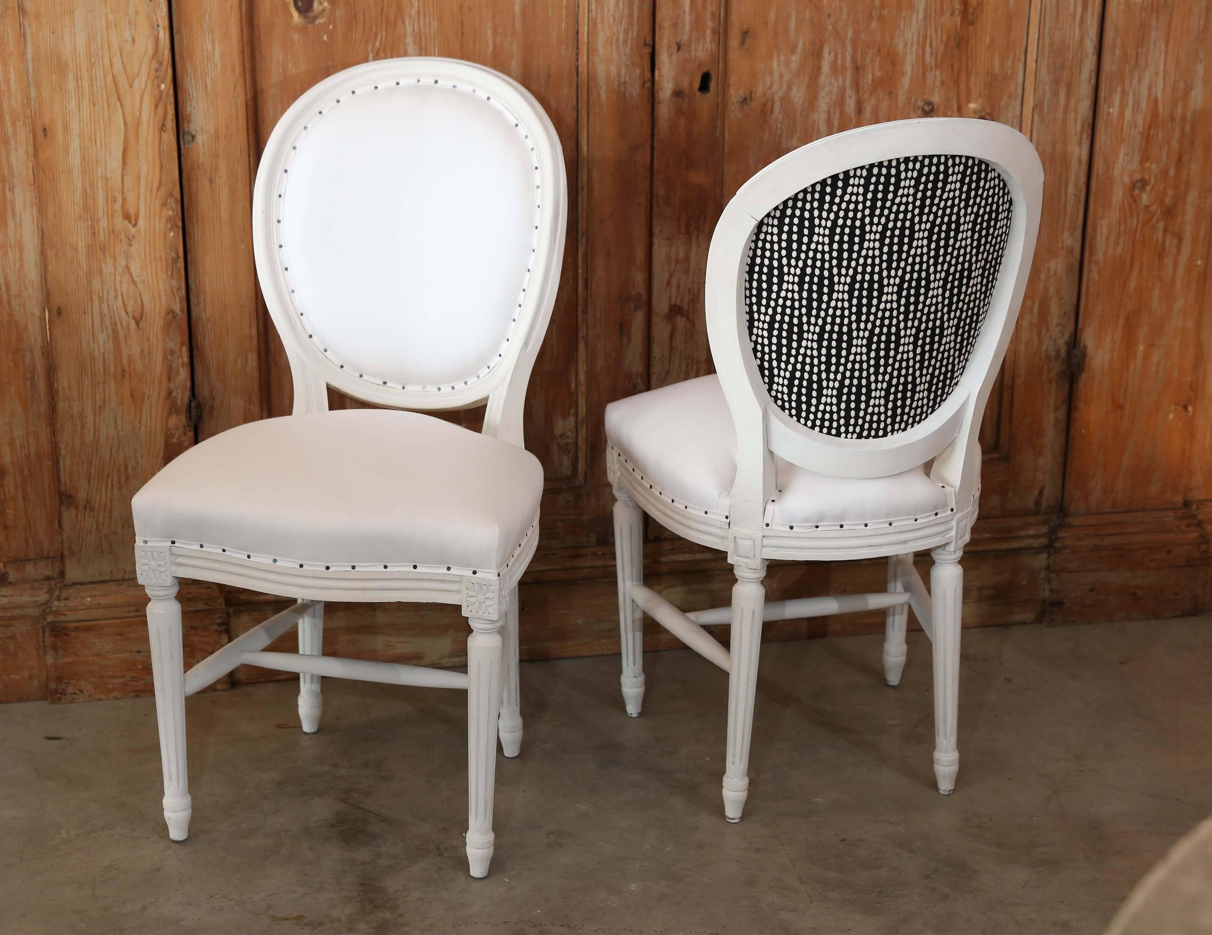 These beautiful set of ten French Louis XVI round back dining chairs, circa 1900 have been newly upholstered in muslin and black and white modern pattern on the back. These are a very comfortable with lots of padding in both the seat and back