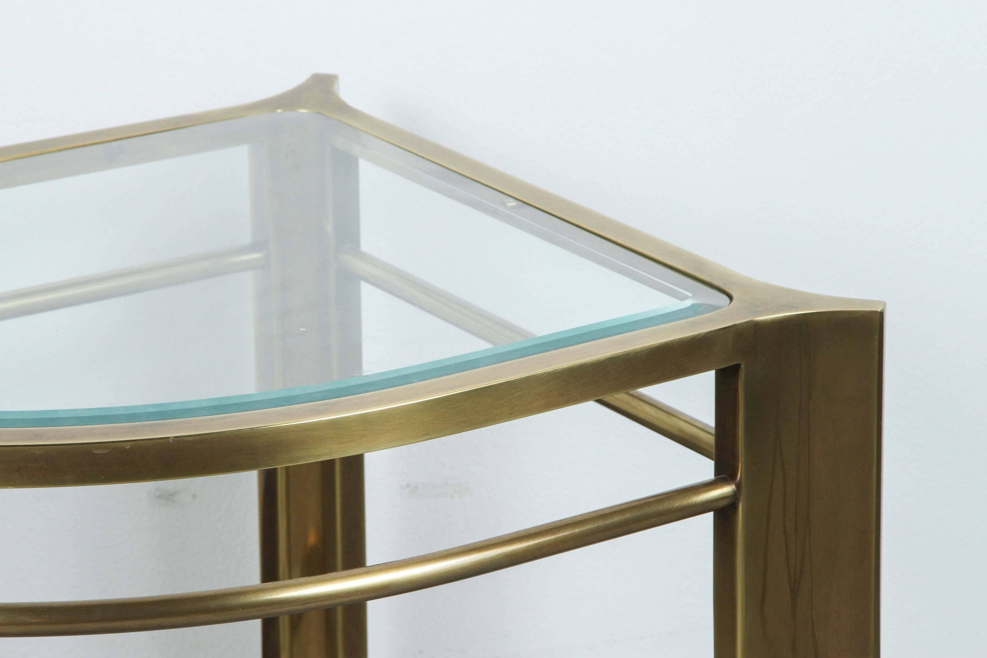 Rare brass and glass corner table by Mastercraft.
The golden / brass frame supports a glass top which is inset.