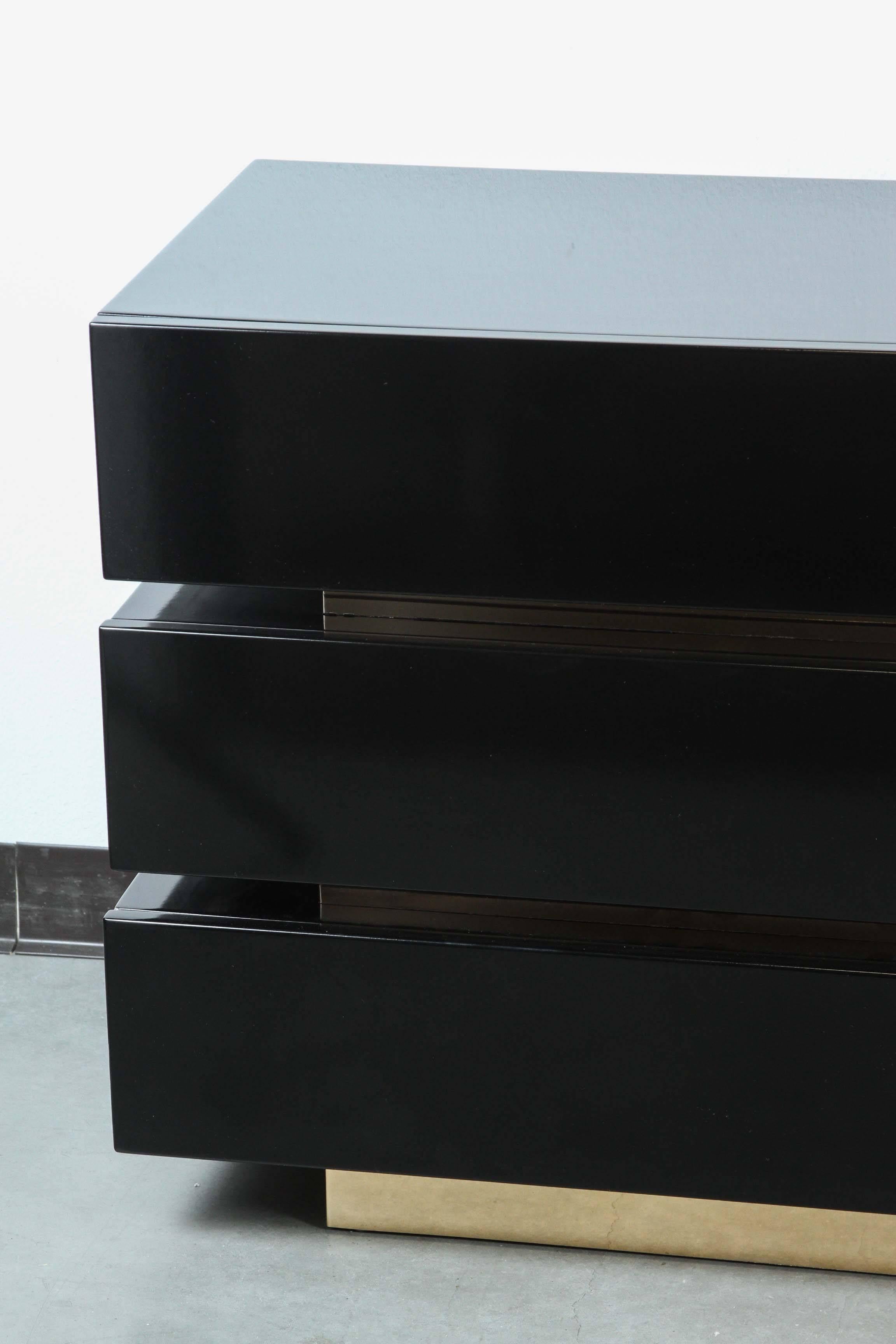 Stunning black lacquered dresser.
The nine-drawer dresser is made up of three pieces that are separated by rich Golden/Brass plinths.
It has been newly refinished in a high gloss black lacquer.