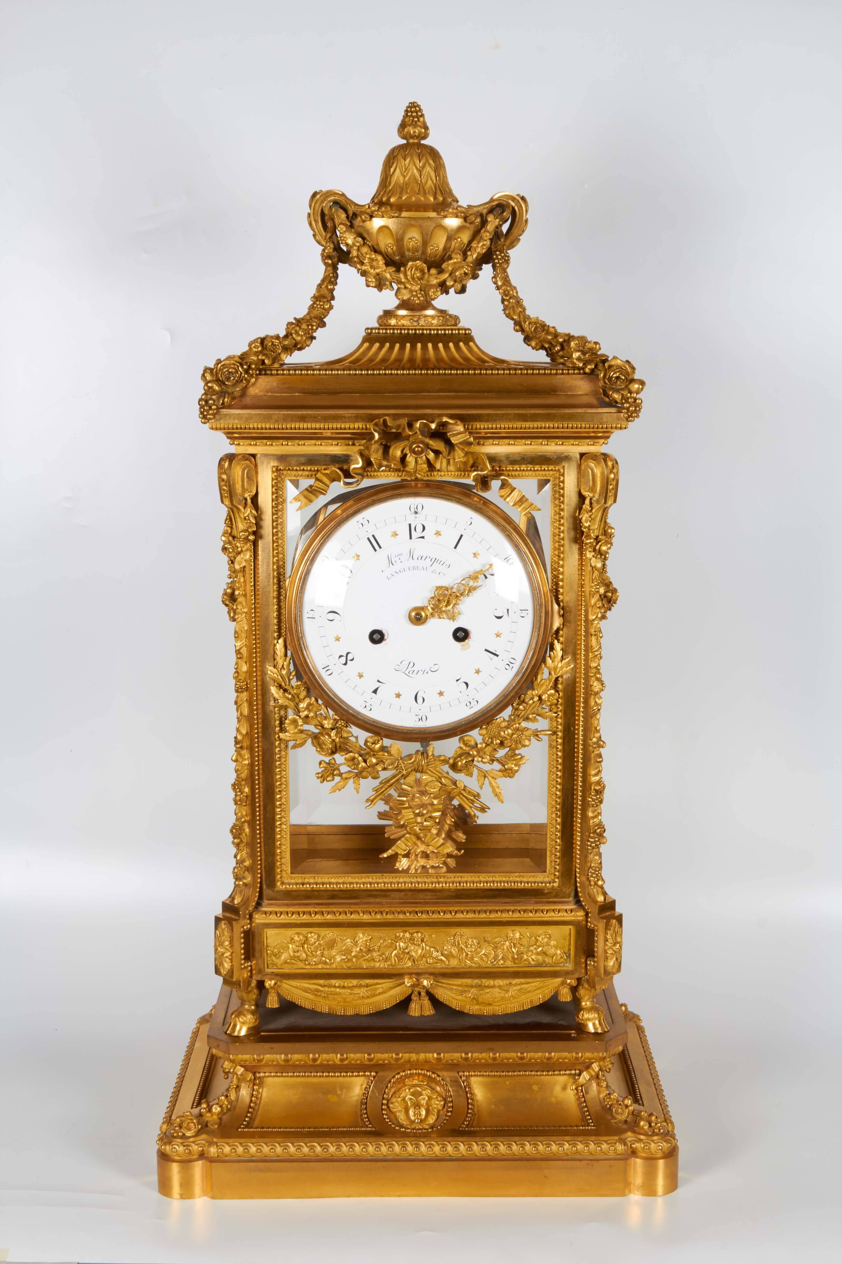 A very unusual and quite monumental antique French Louis XVI style Napoleon III ormolu mantel clock by Maison Marquis, the Movement by Languereau, Paris, 1860: surmounted by an urn issuing flower swags, the rectangular body with beveled glazed front