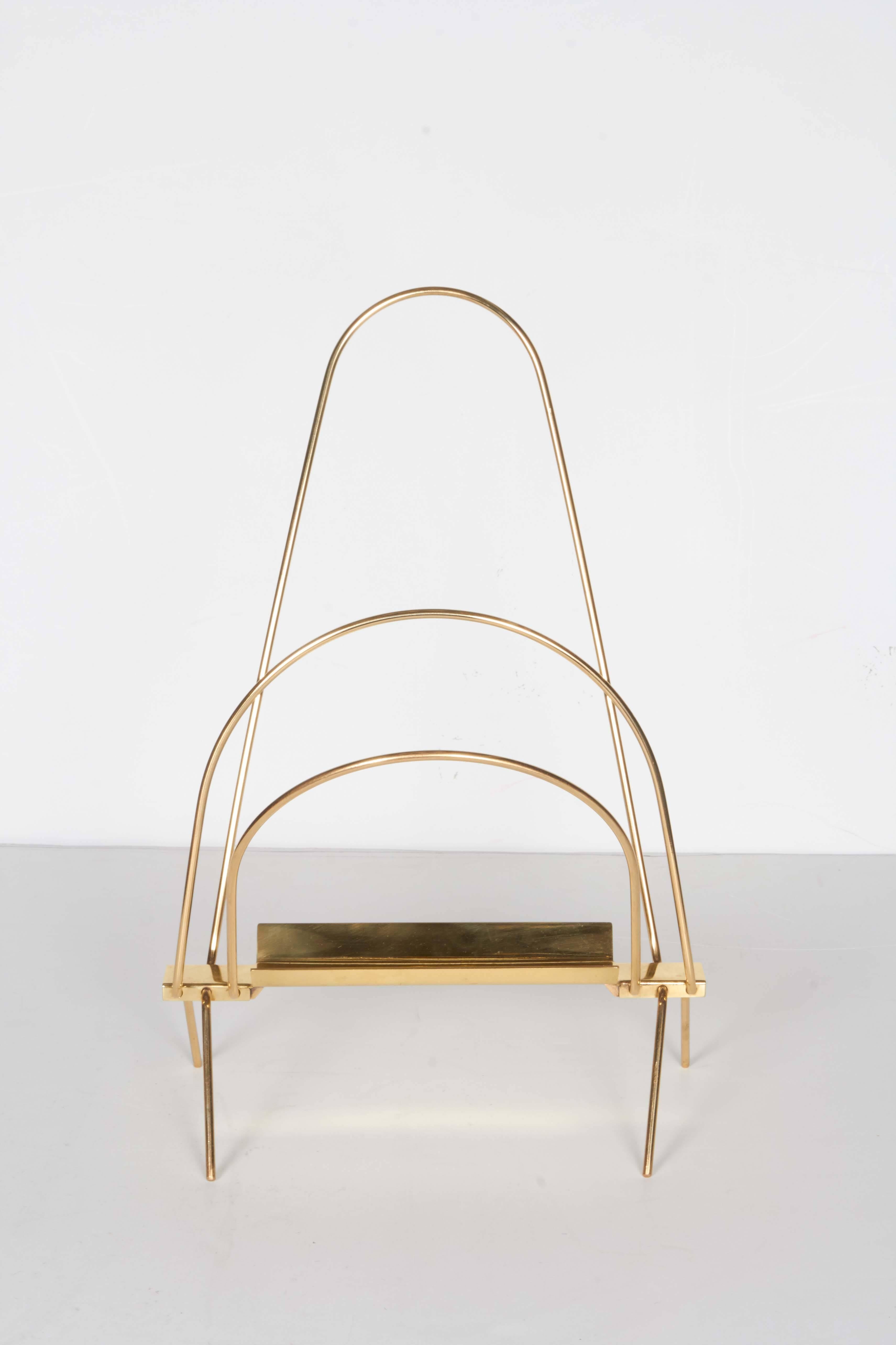 A very nicely made Italian 1950s magazine rack. The clean and modern triple arc design in bent brass rods allows the piece to stand alone without or with magazines. Brass newly polished and lacquered.