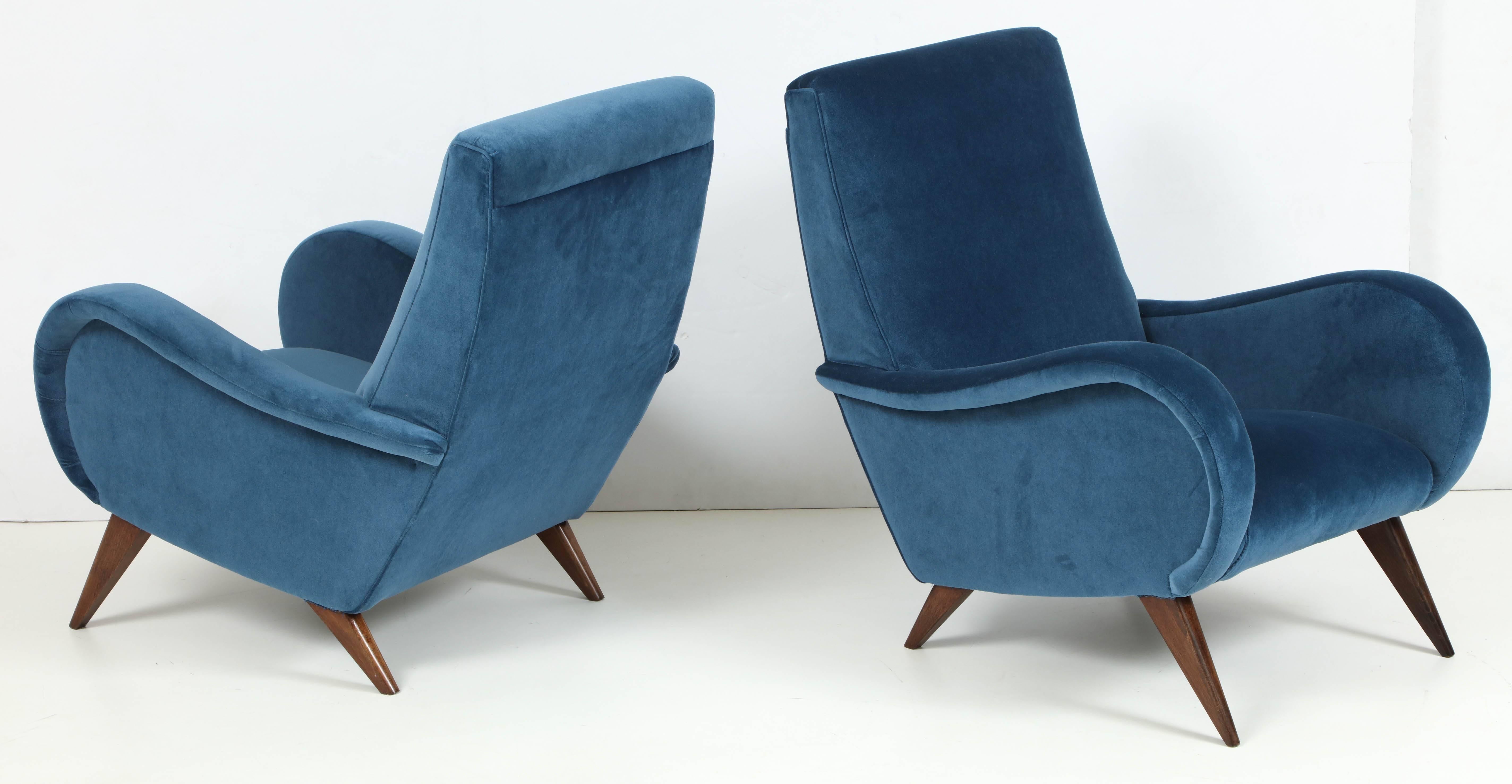 Fabulous style and craftsmanship, this pair of Italian Mid-Century Modern lounge chairs are as beautiful as they are comfortable. Quintessential Italian style in its curvy arms and simplistic style. Professionally restored down to the hand polished