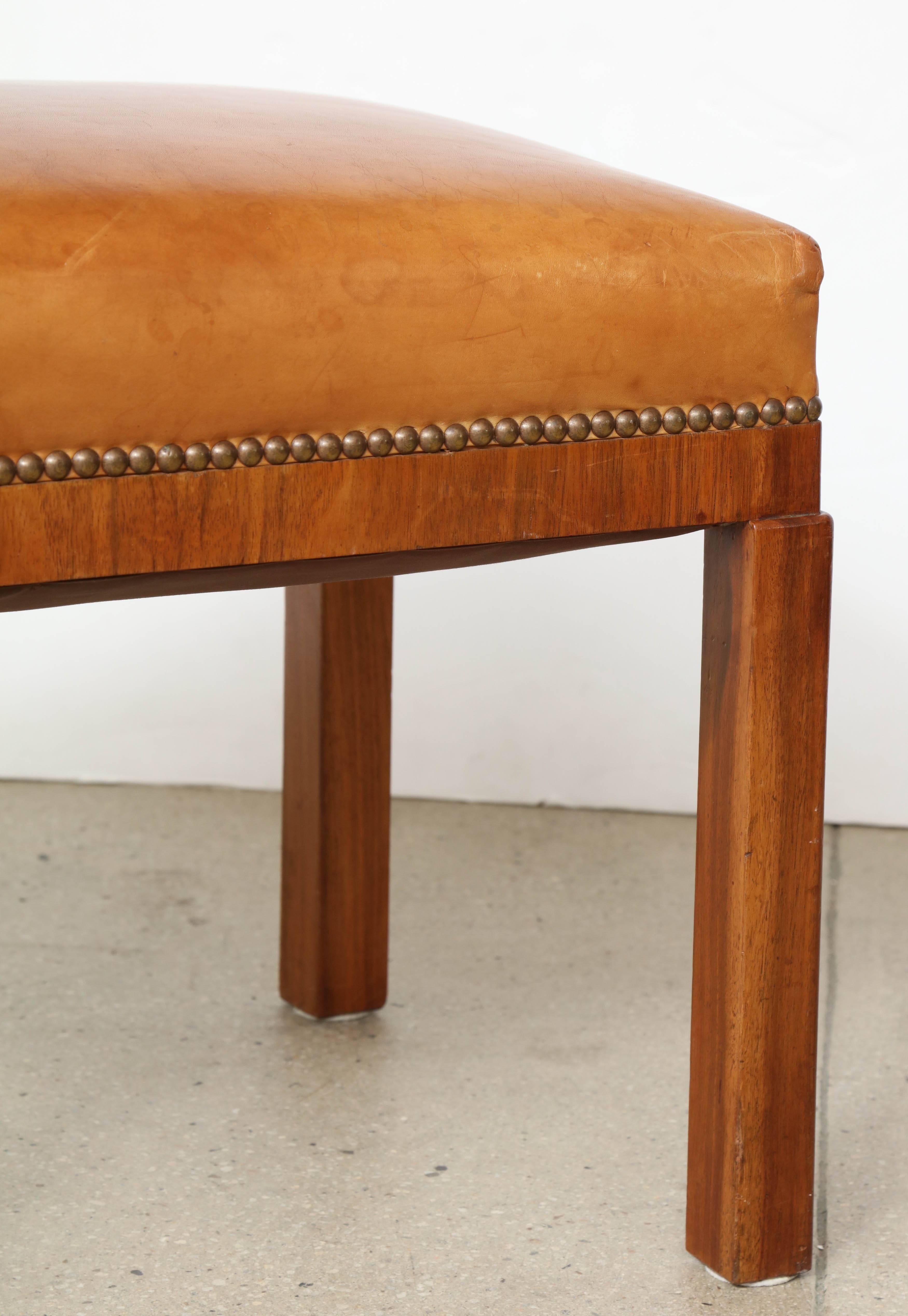 Elegant 1930s Swedish Grace figured walnut stool with beautiful original saddle hide upholstery, attributed to Erik Chambert. Very good original condition throughout.