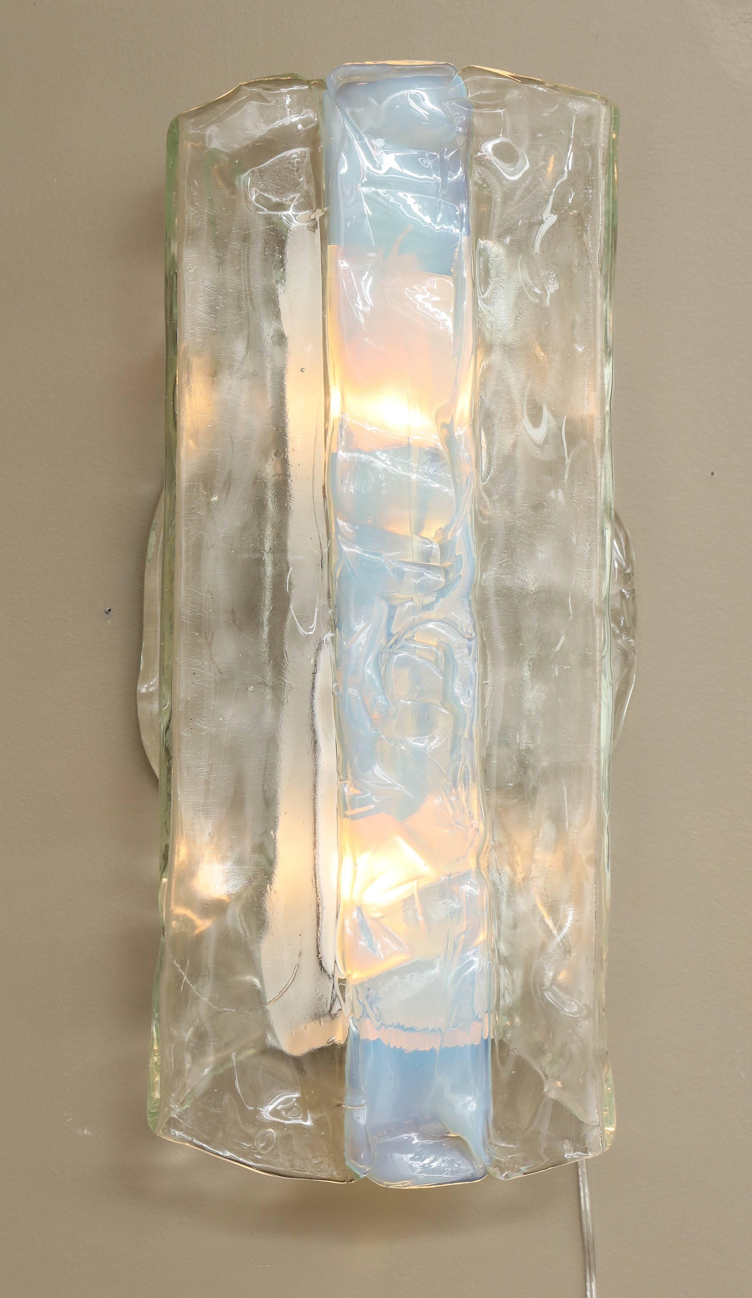 A large circular transparent Murano glass disc ornamented with a single vertical band of opalescent glass is 