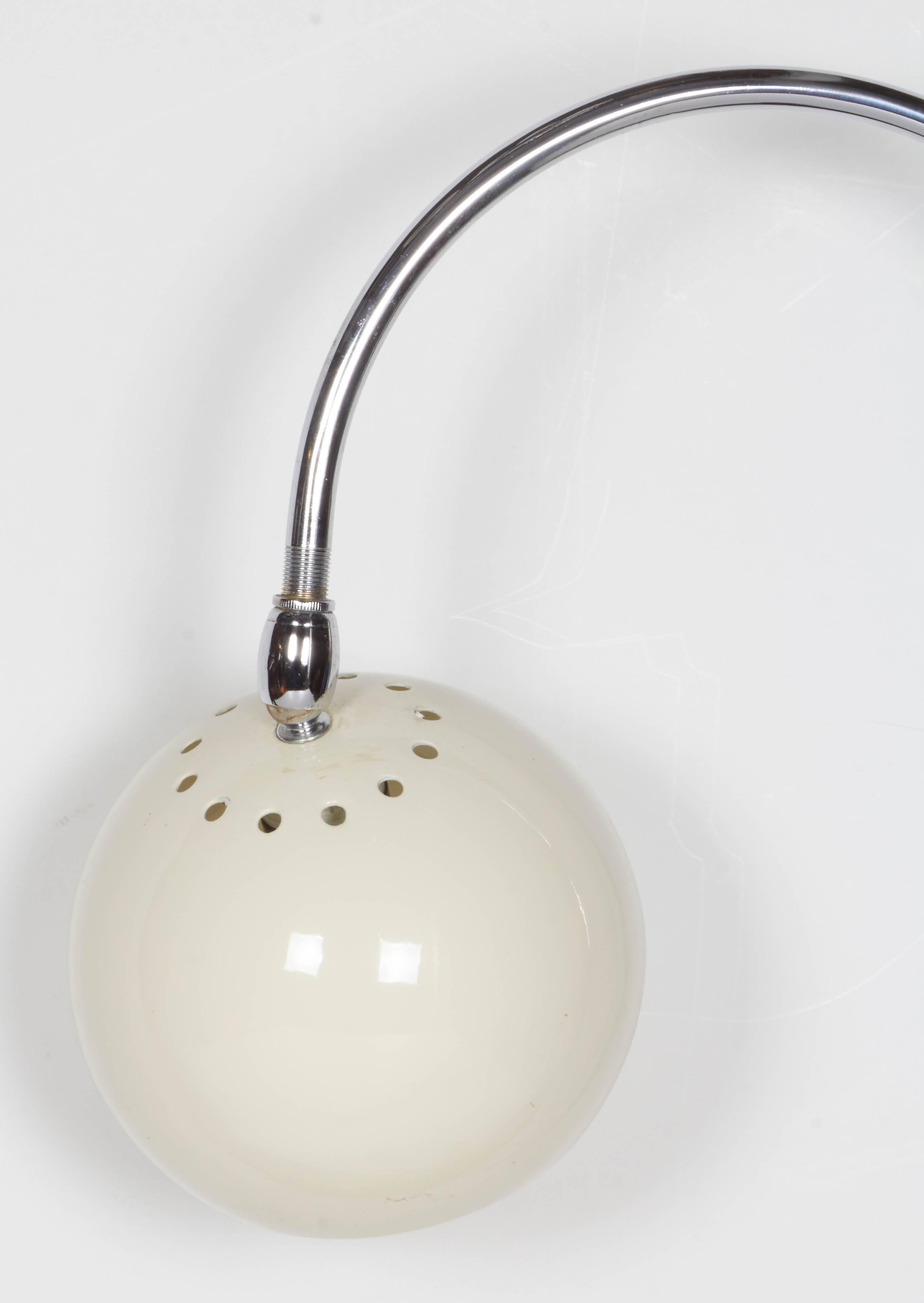 A fun piece of 1970s Italian mod design lighting. An off-white enamel globe is suspended from a chromed goose neck rod that has a black plastic screw on table or desk attachment. Requires on candelabra bulb. Rewired. Measures 10 inches wide and 22