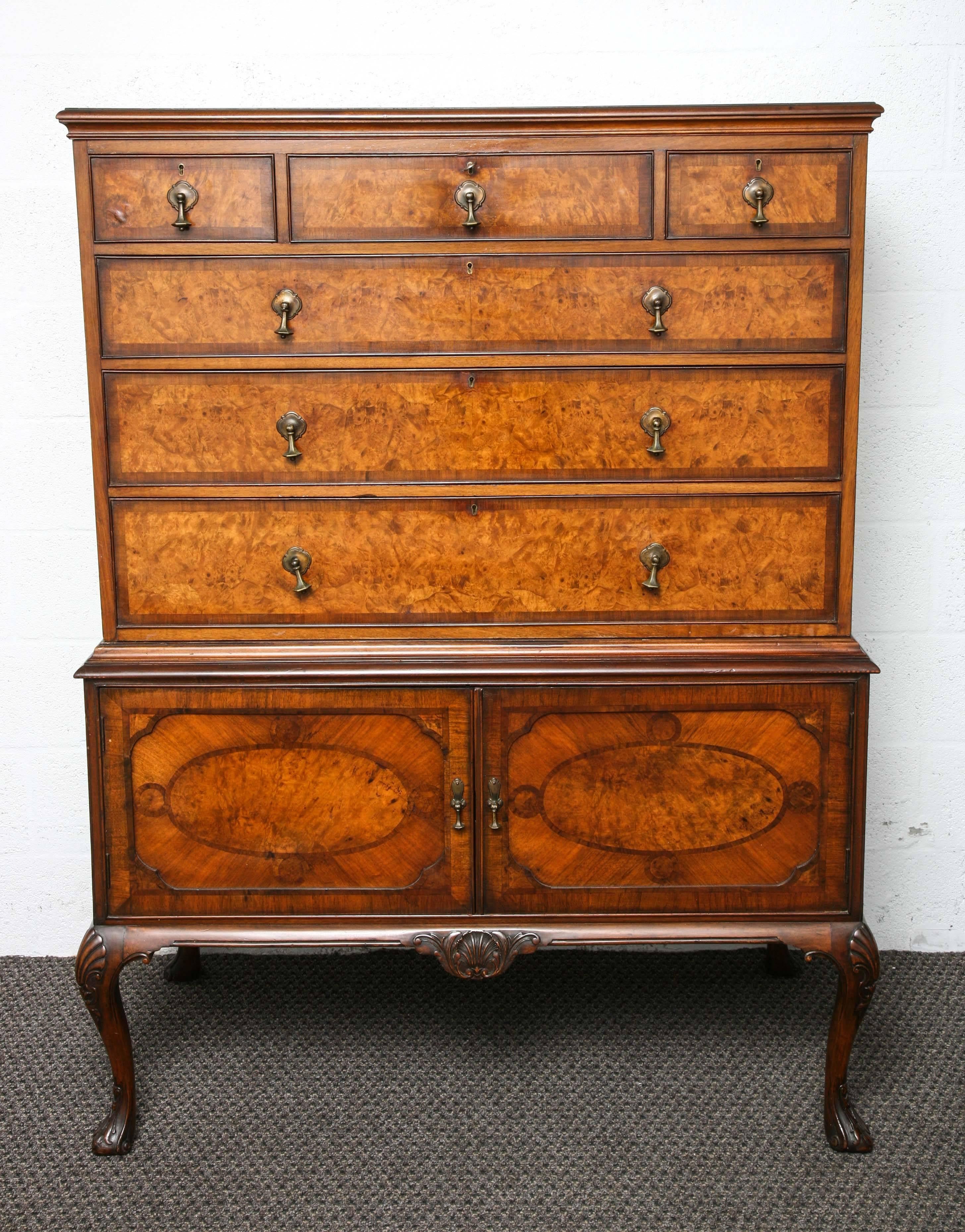 This is a superb burr walnut chest on stand which was made in England, circa 1920, it sits on Queen Anne style legs and has two-door to the base above there are drawers which are all solid wood and dovetail joints, with the original brass
