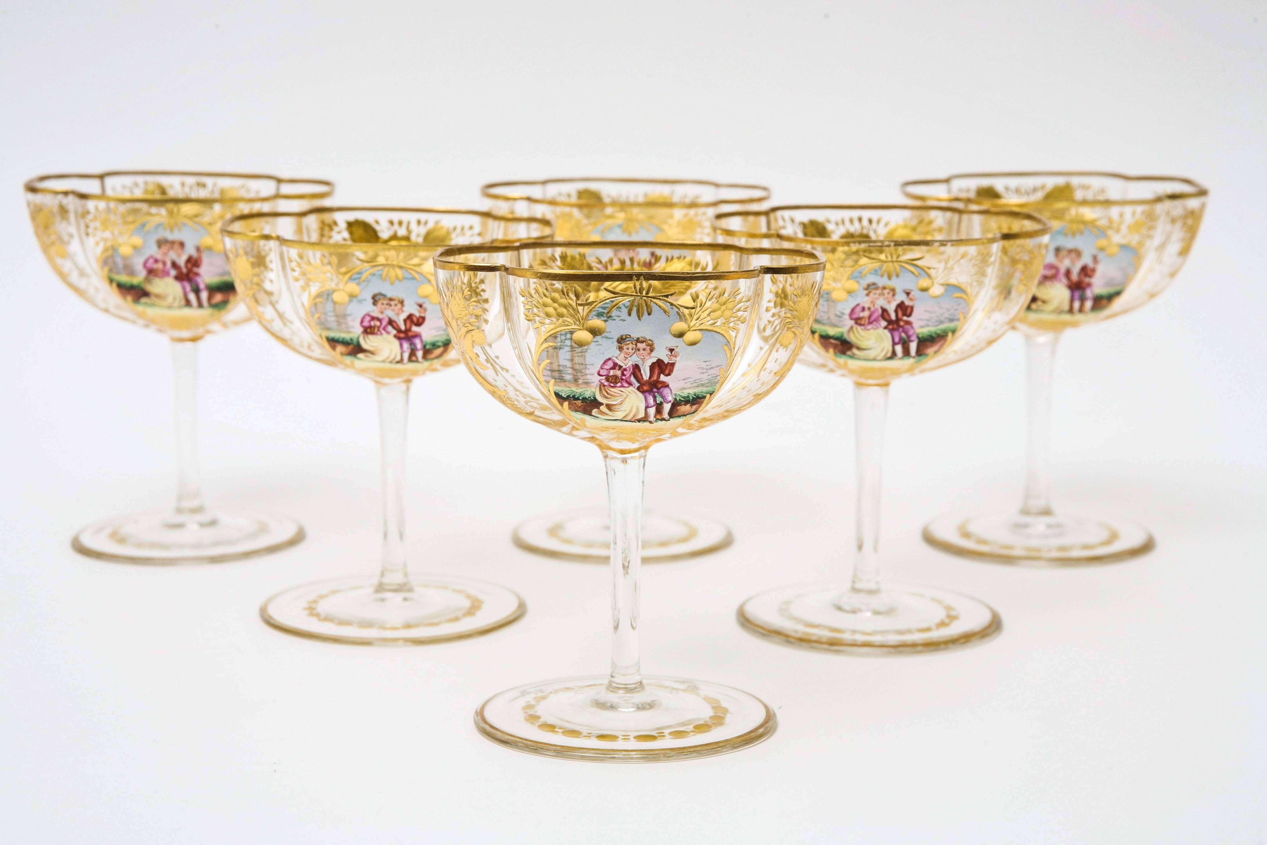 A delightful set of six antique champagne glasses attributed to the Moser factory. One of their signature shapes with beautifully cut and gilded all-over design and cartouches of romantic scenery. These precious pieces have matching wine glasses