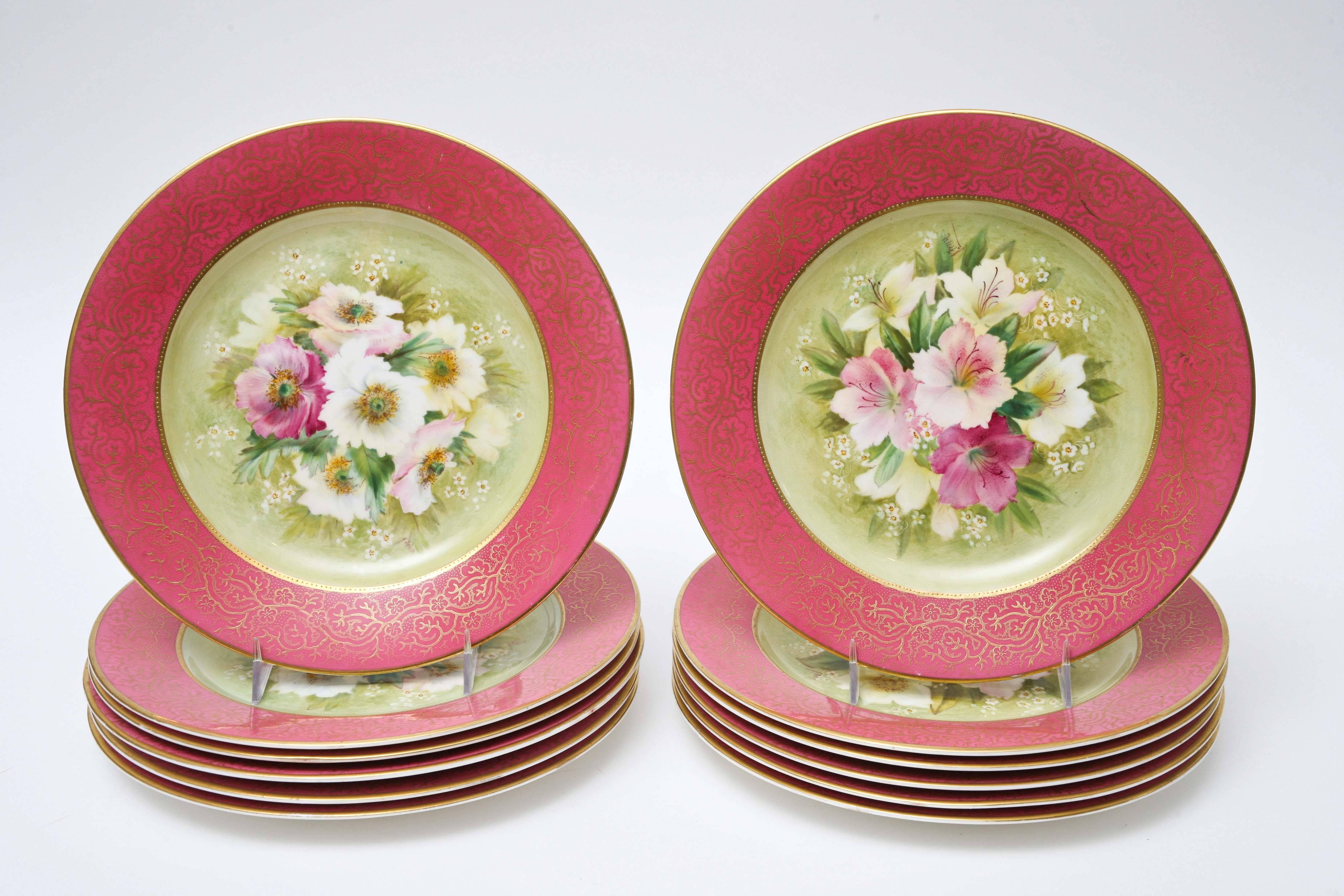 A stunning and classic set of 12 English fine porcelain plates by George Jones, Crescent & Sons, circa 1910 and in wonderful antique condition. The versatile plates feature 24-karat gilt scroll design on a pink shoulder and lush hand-painted