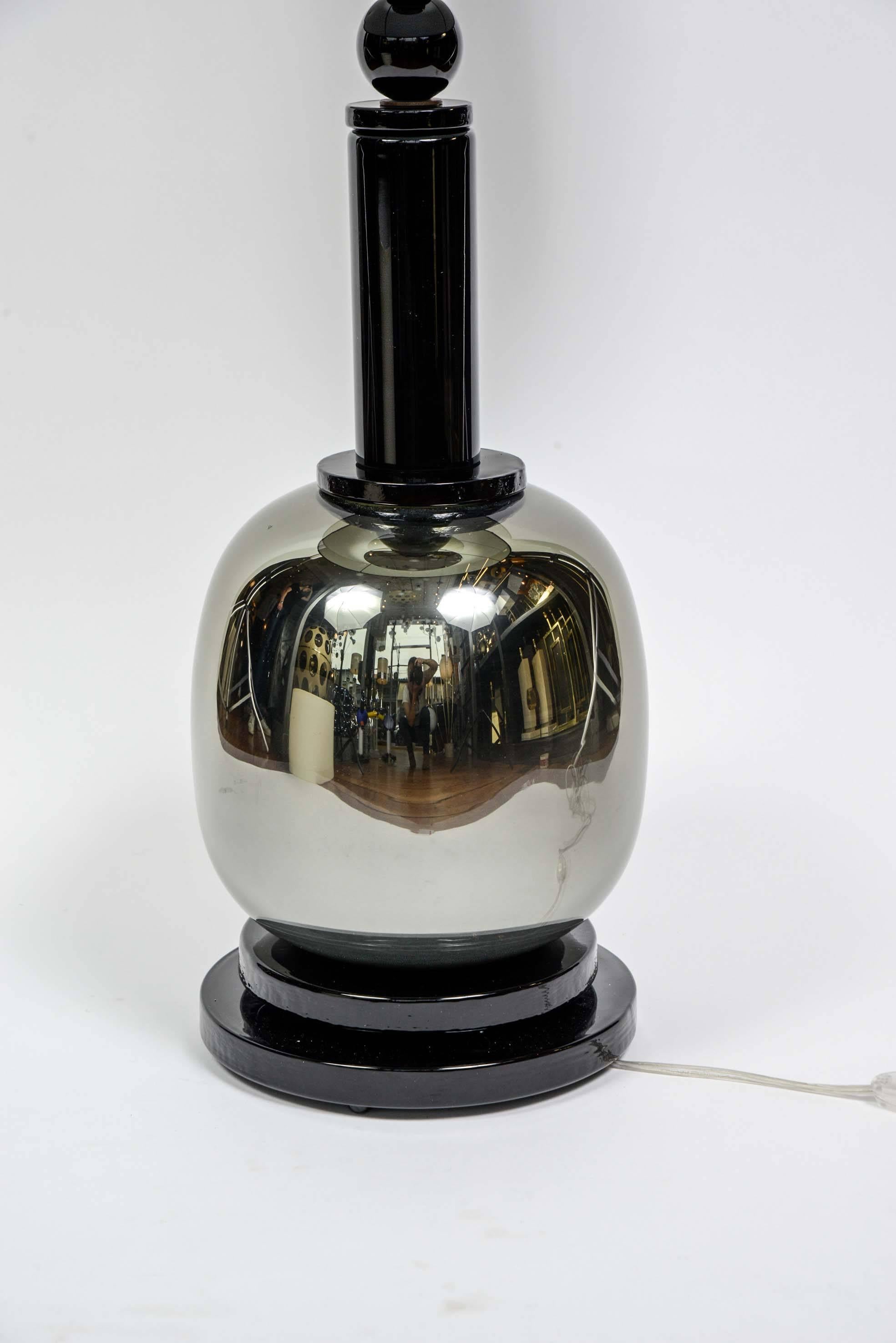 Lampenpaar aus getöntem Muranoglas, ein breiter Fuß hält eine glänzende, reflektierende Kugel, aus der ein langer schwarzer Hals herausragt.