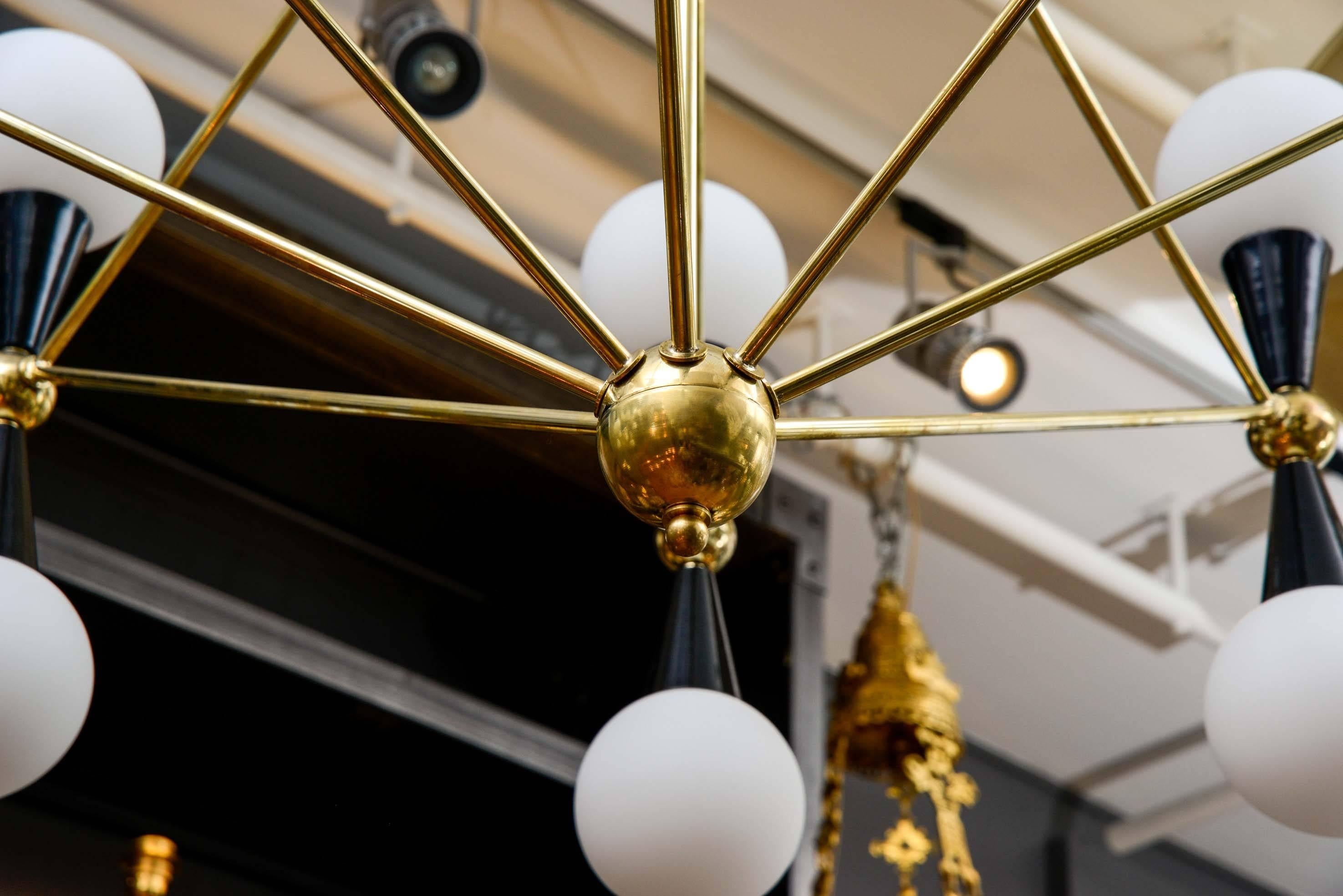 Contemporary Wide Symmetrical Pair of Brass Chandeliers with Globes