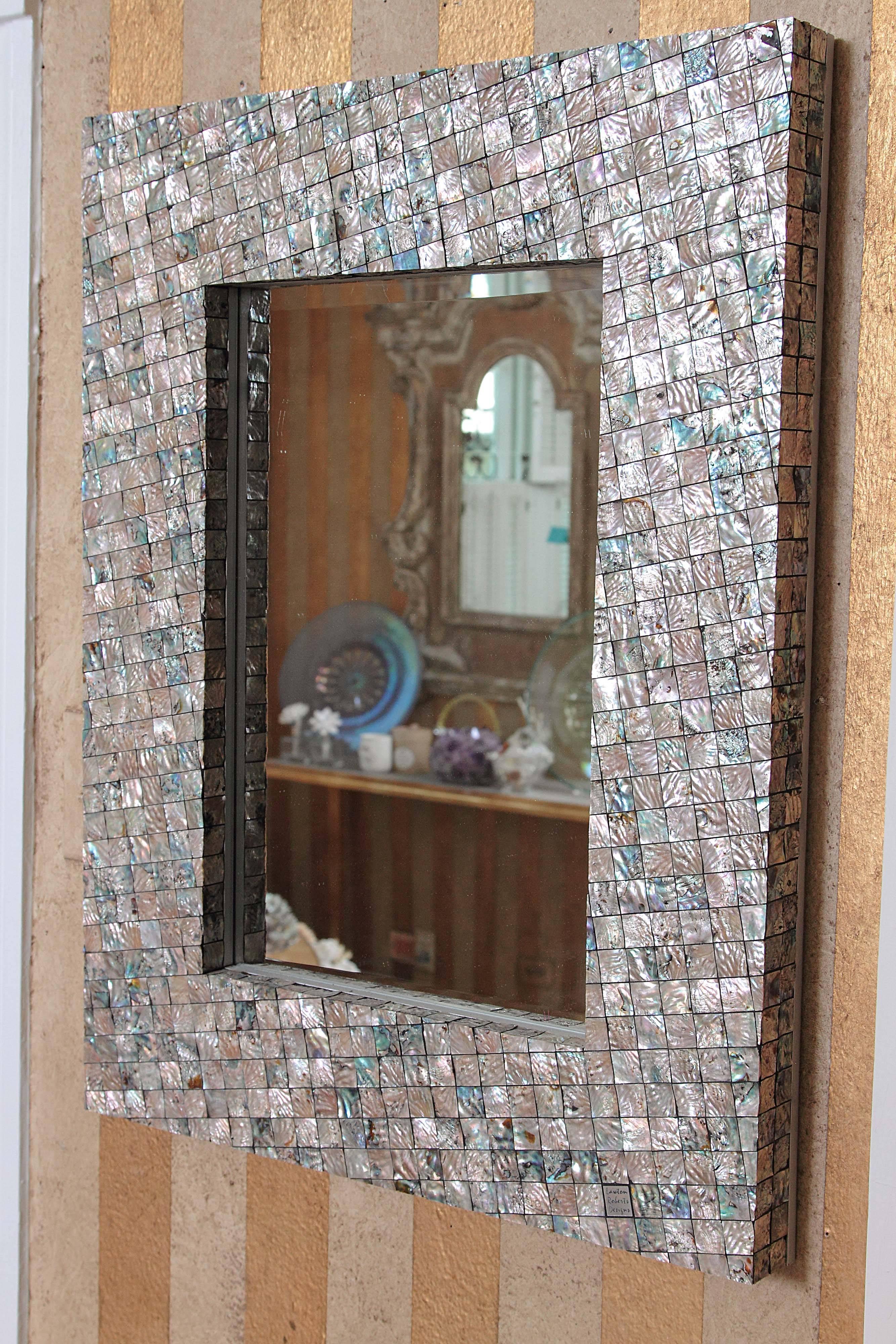 This is a handmade abalone shell mirror made by South African artist. Each shell is individually cut and placed to create this mosaic style.