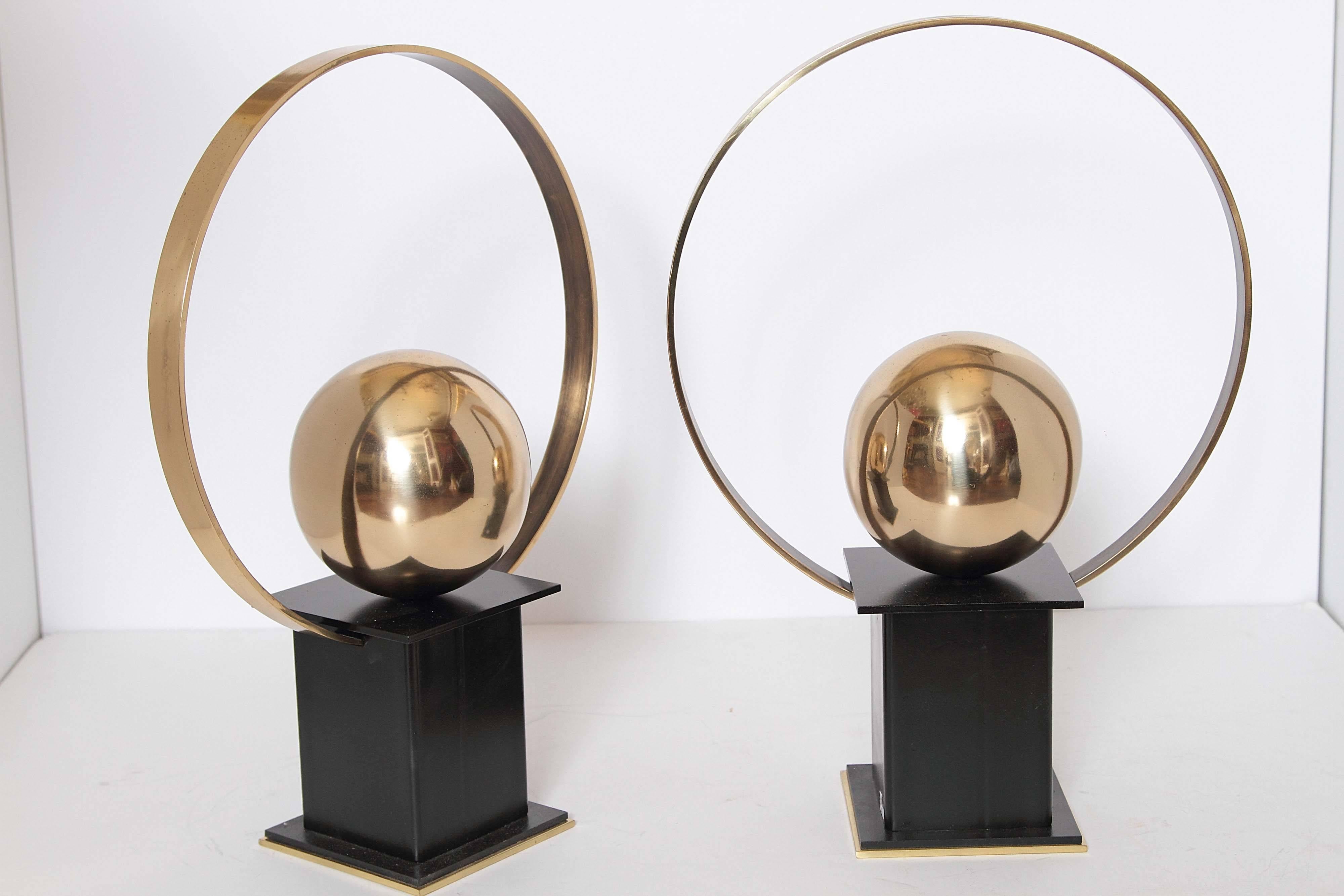 Pair of custom-made lack and gold andirons designed by Sherry Hayslip for Whitesmith & Company. The circular steel haloes surrounding the polished brass spheres are placed on black steel bases.