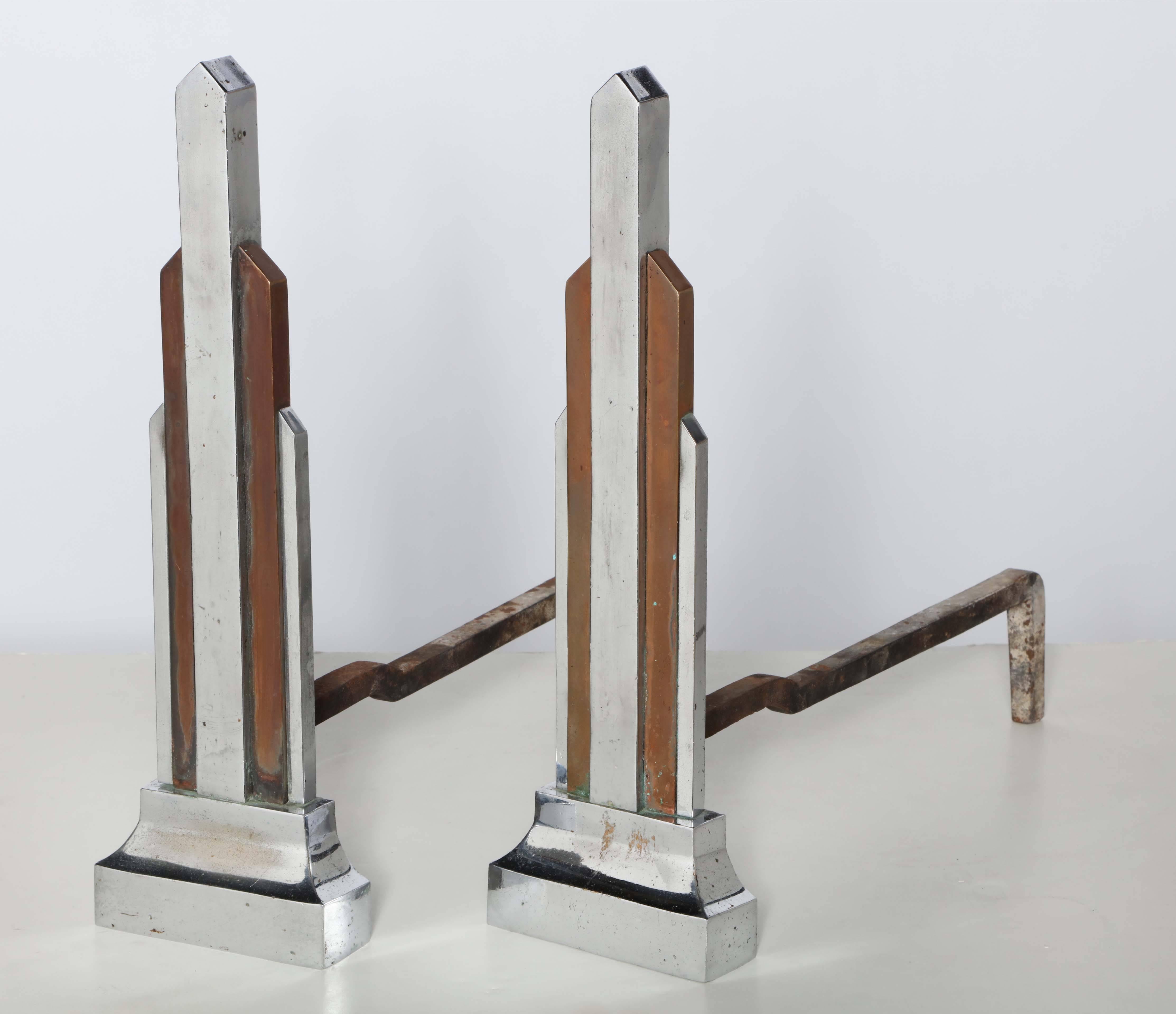 Late 1920s Chrome-Plated Iron and Brass Skyscraper Andirons. Classic American Art Deco design with Cast Iron firedog legs. Architectural front in Chrome-plated Iron and Brass.
